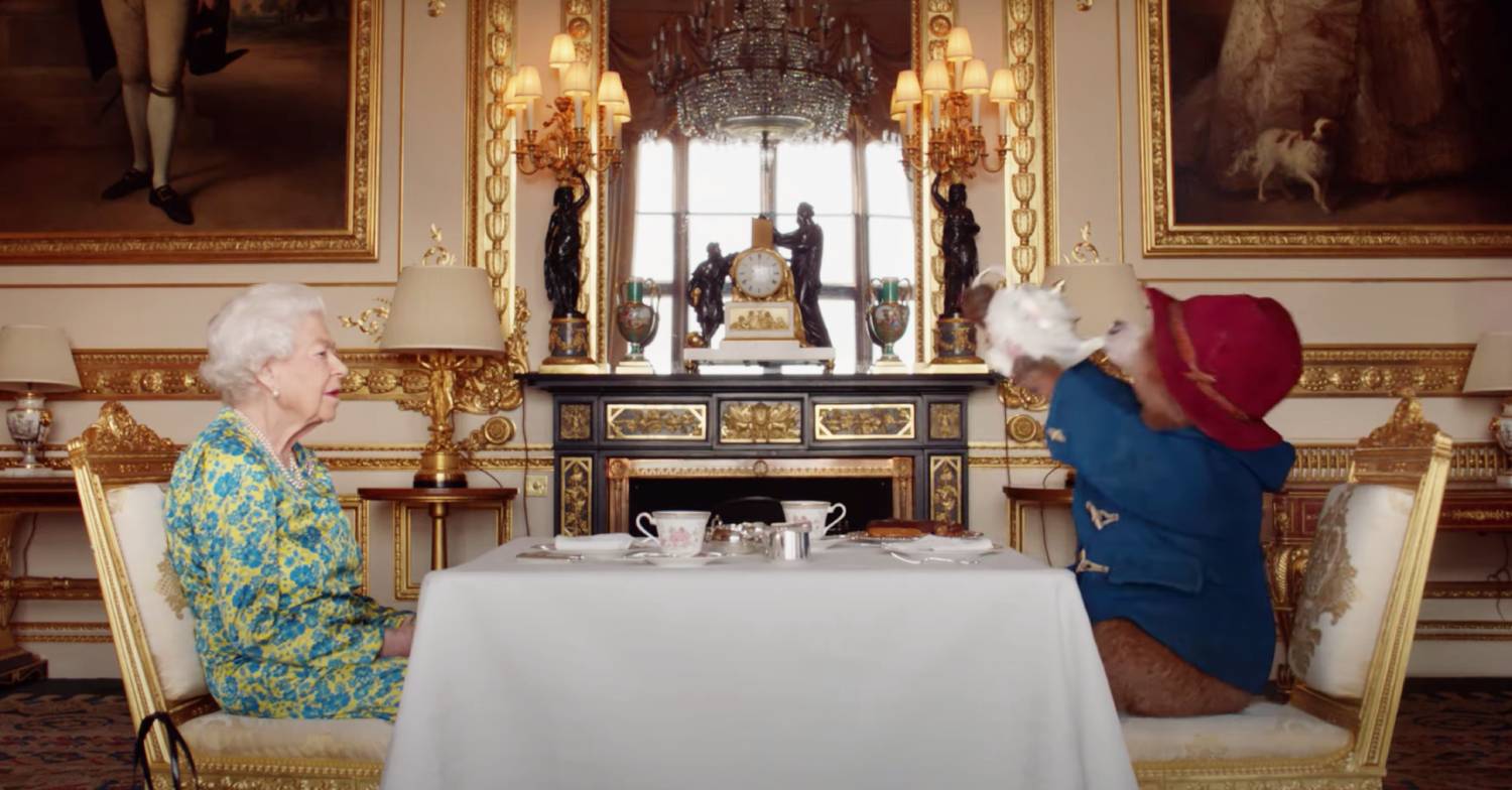 The Queen watches on as Paddington Bear slurps tea
