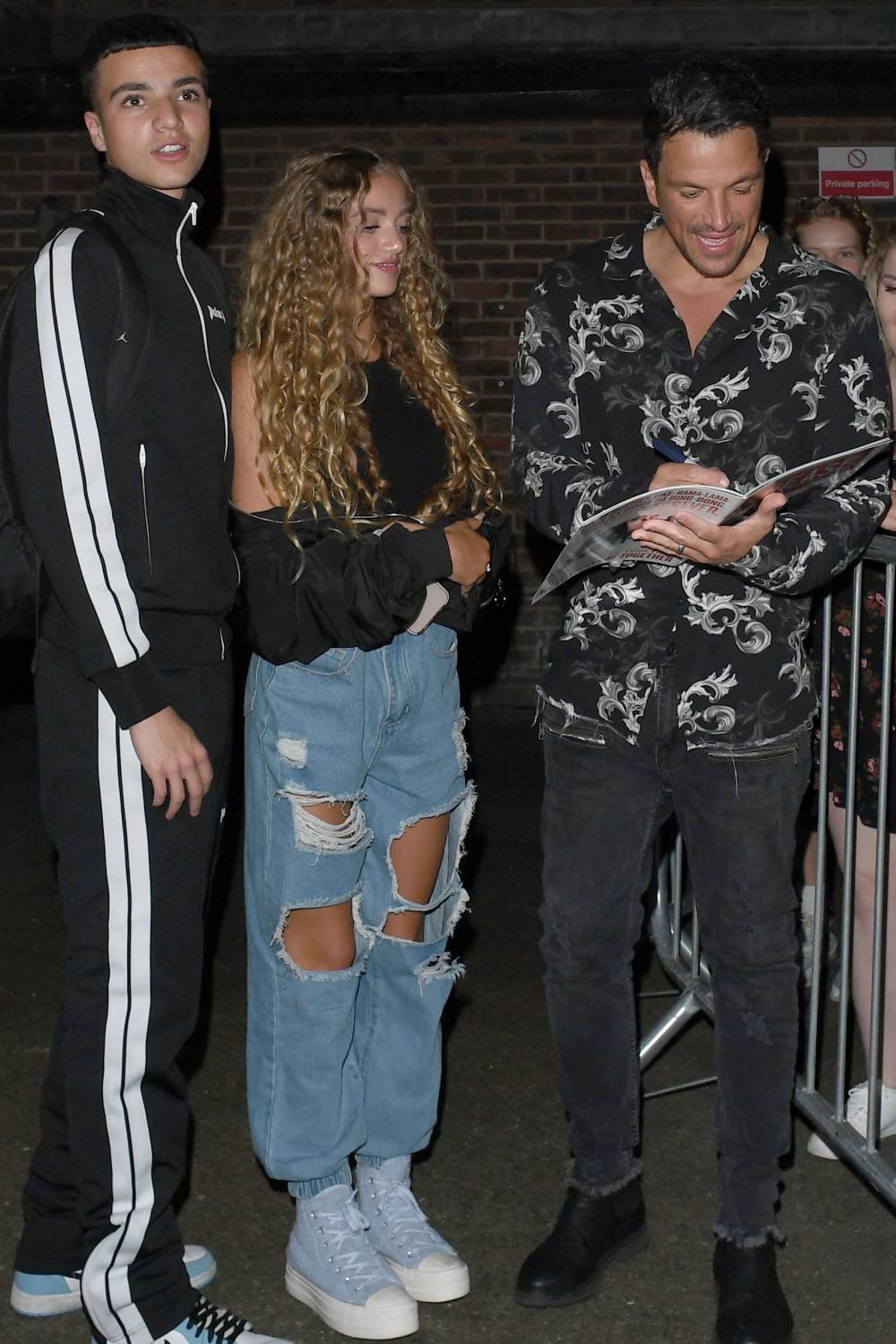 Peter Andre signs autographs as his kids look on