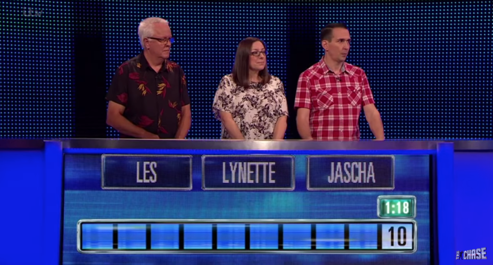 Three contestants stand behind the podium on The Chase on ITV