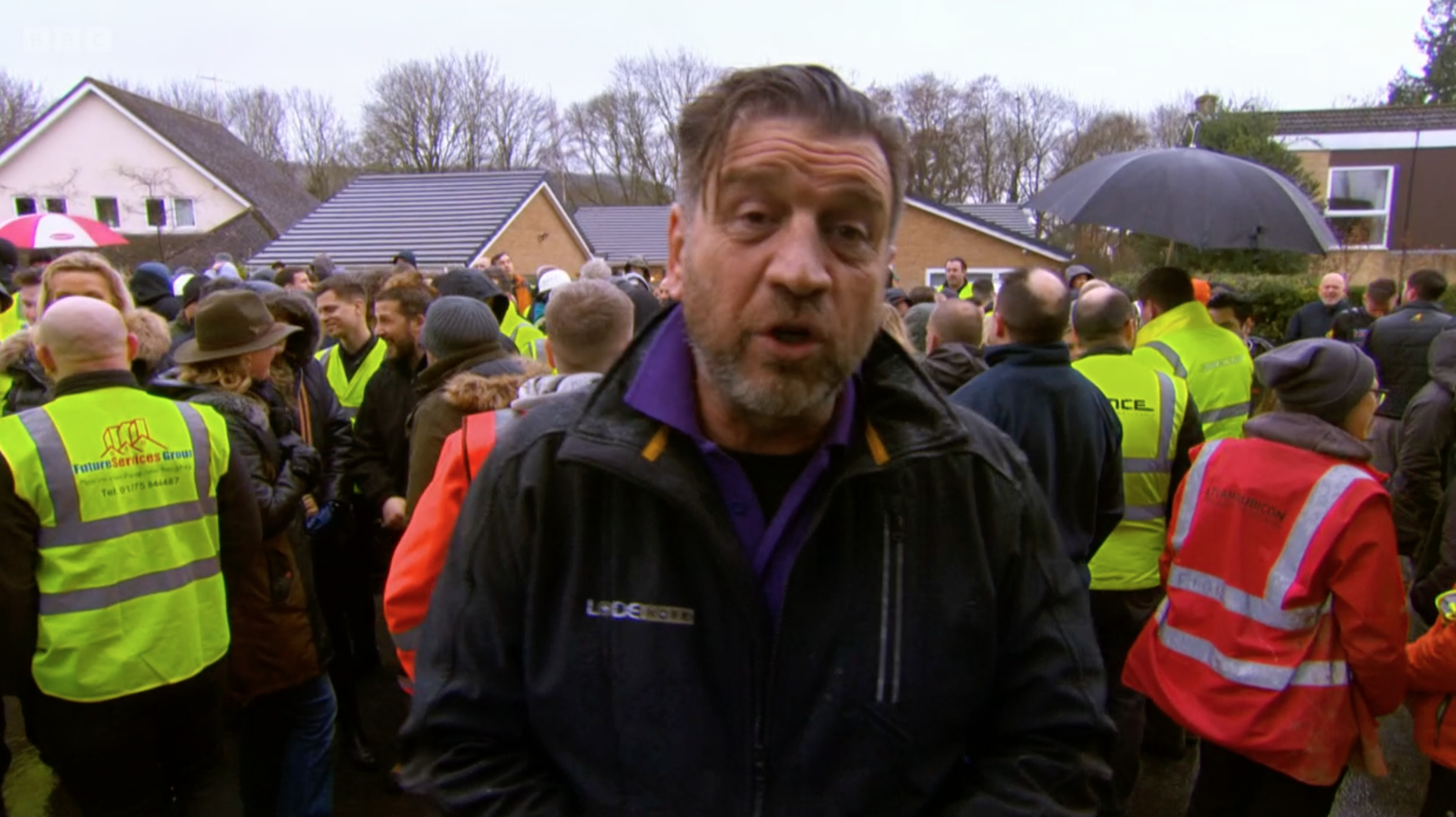 Nick Knowles in the rain with the DIY SOS team