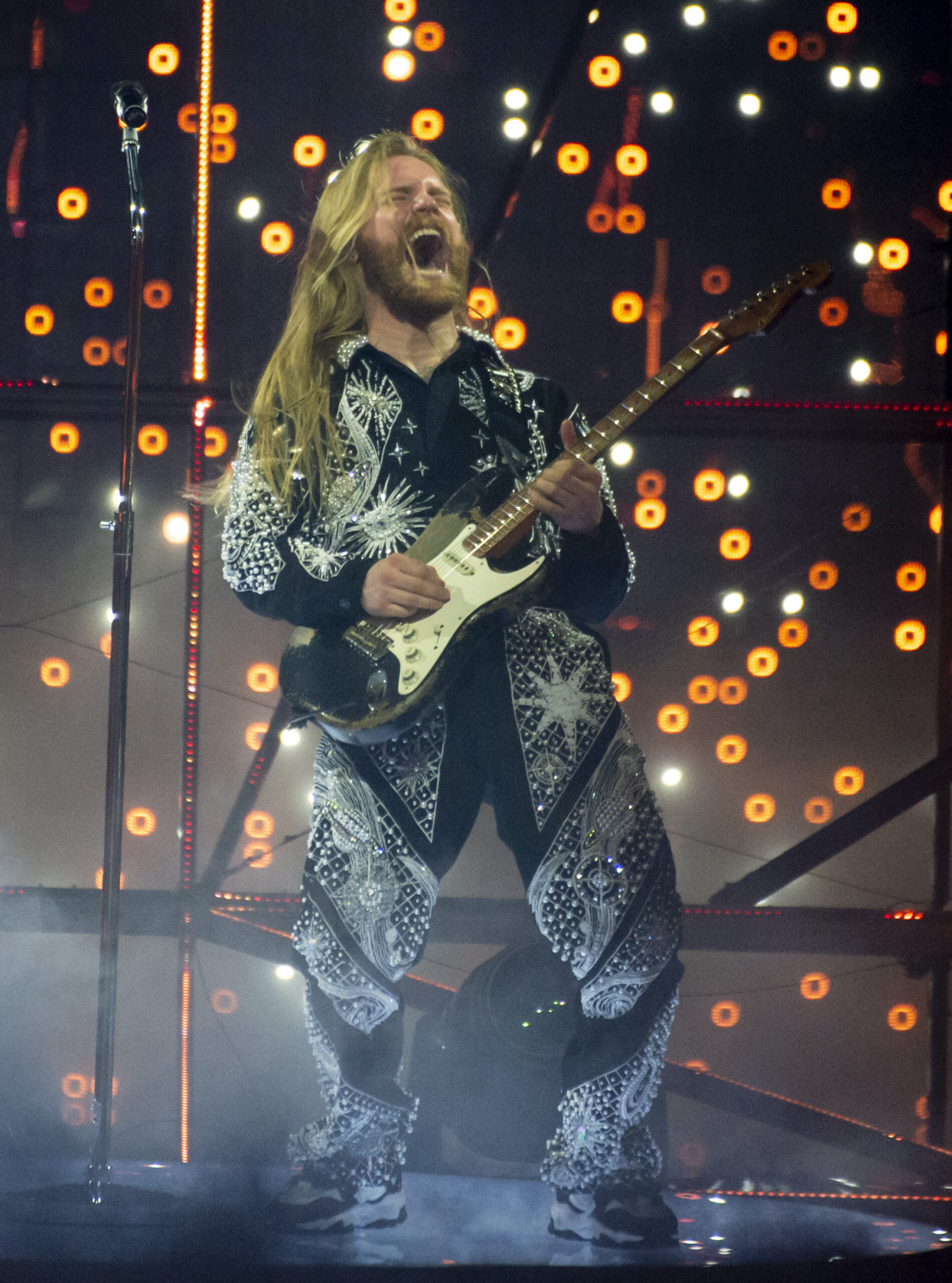 Eurovision 2022 UK entry Sam Ryder sings on stage holding a guitar