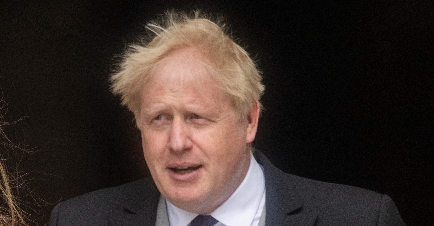 Boris Johnson smiling in a black suit