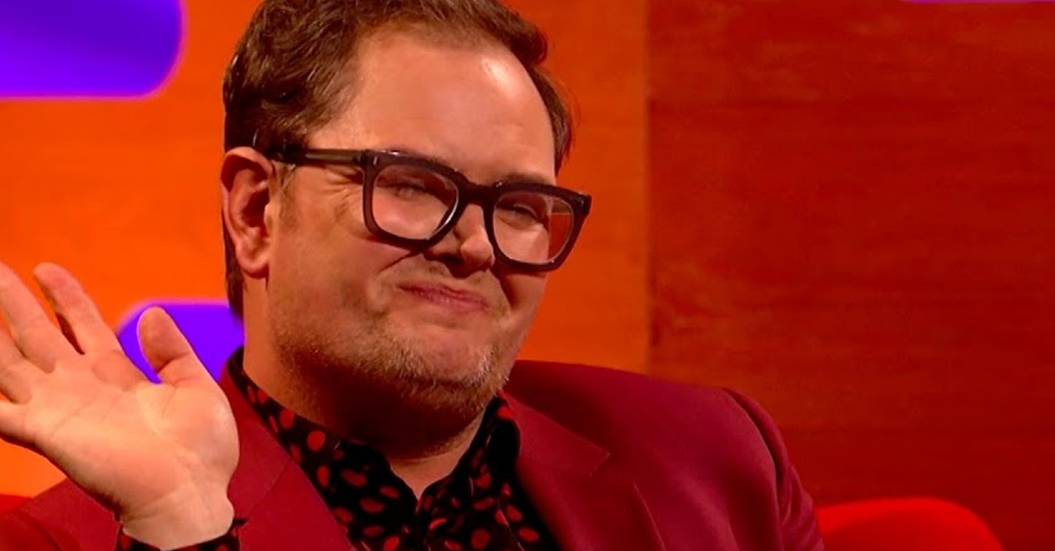 Alan Carr smiling and waving on Graham Norton