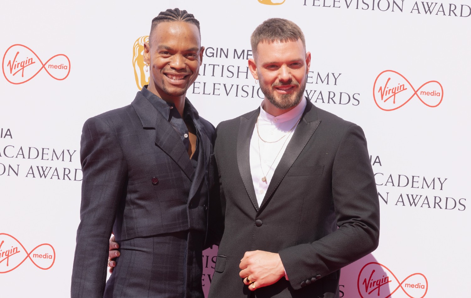 Johannes Radebe smiling on the red carpet with John Whaite
