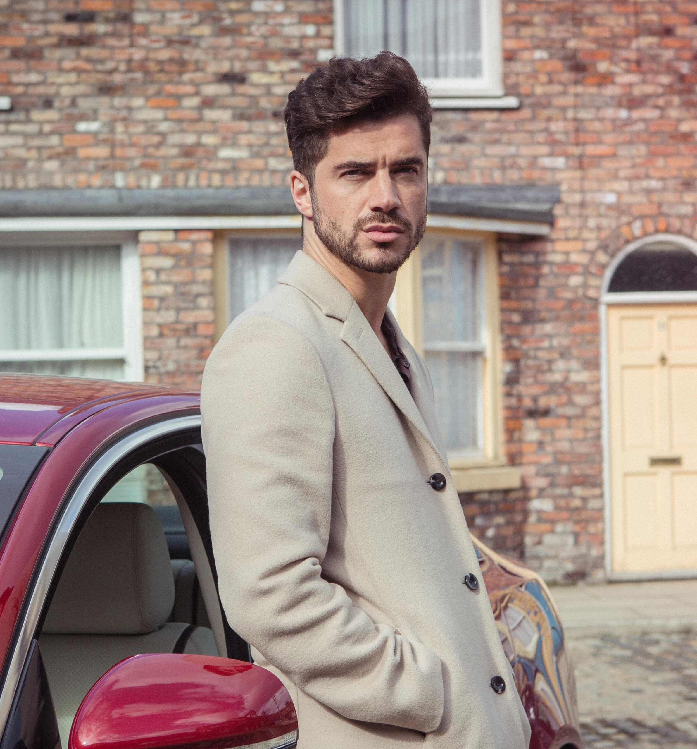 Adam Barlow leans against his car