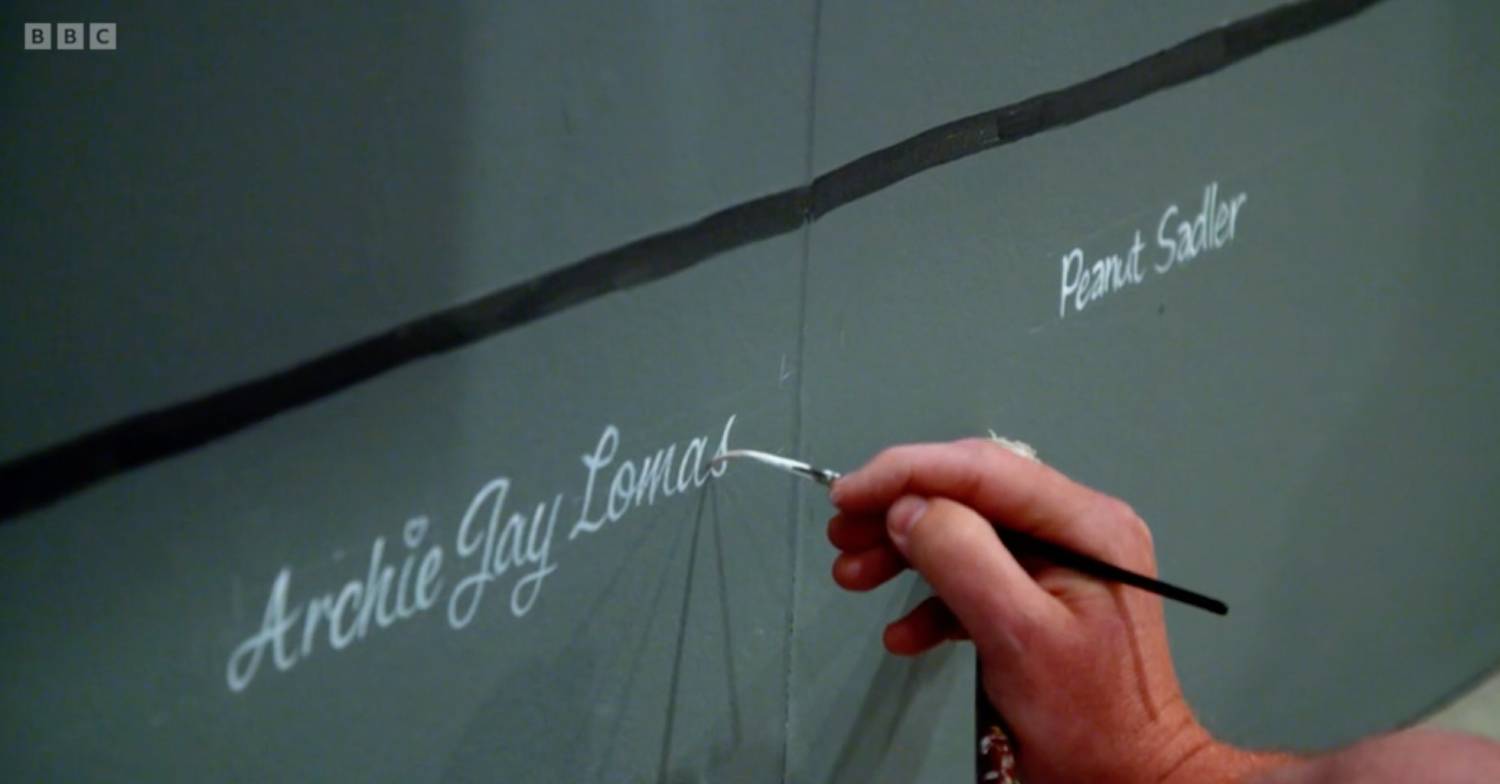 A signwriter paints Archie's name