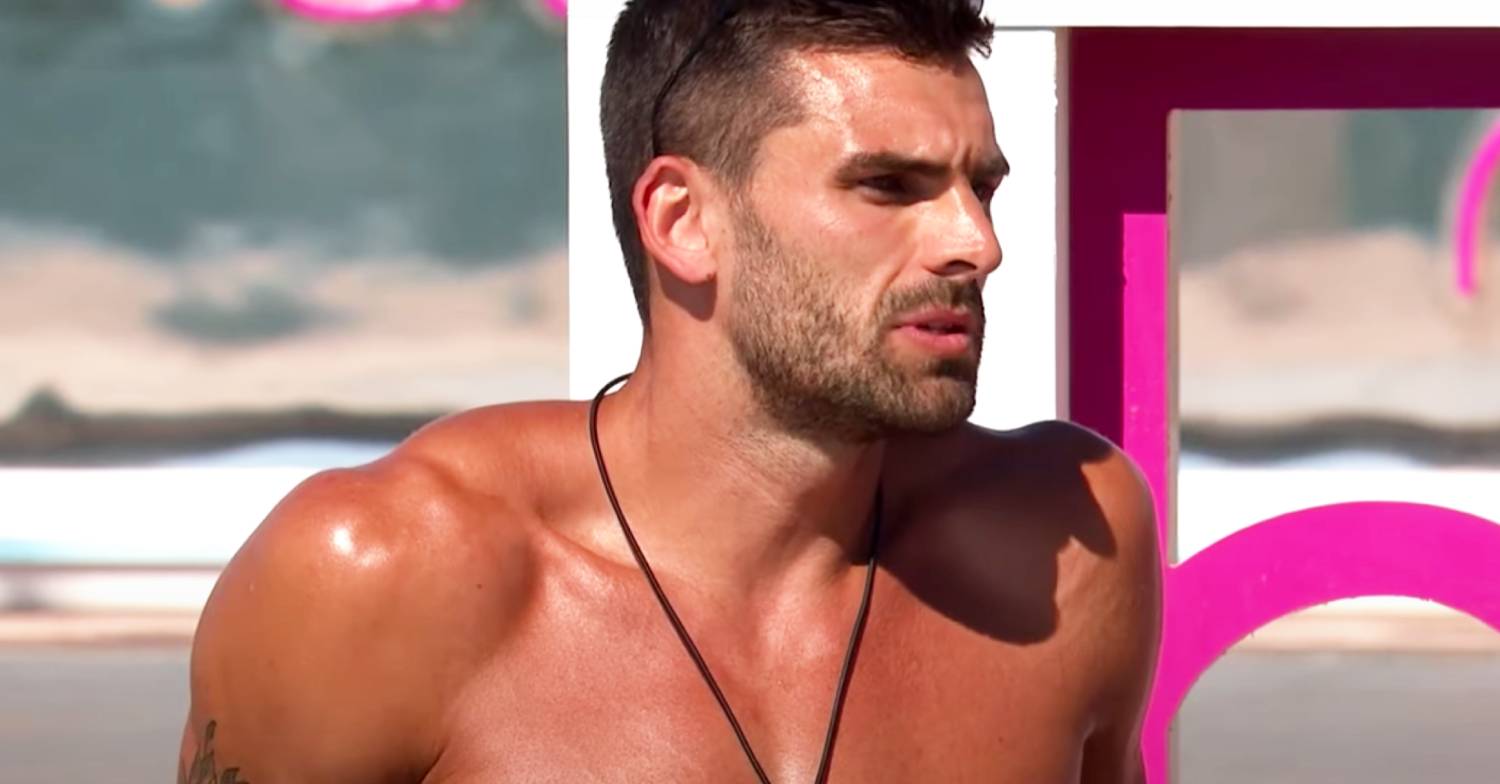 Adam Collard frowns as he soaks up the sun on Love Island