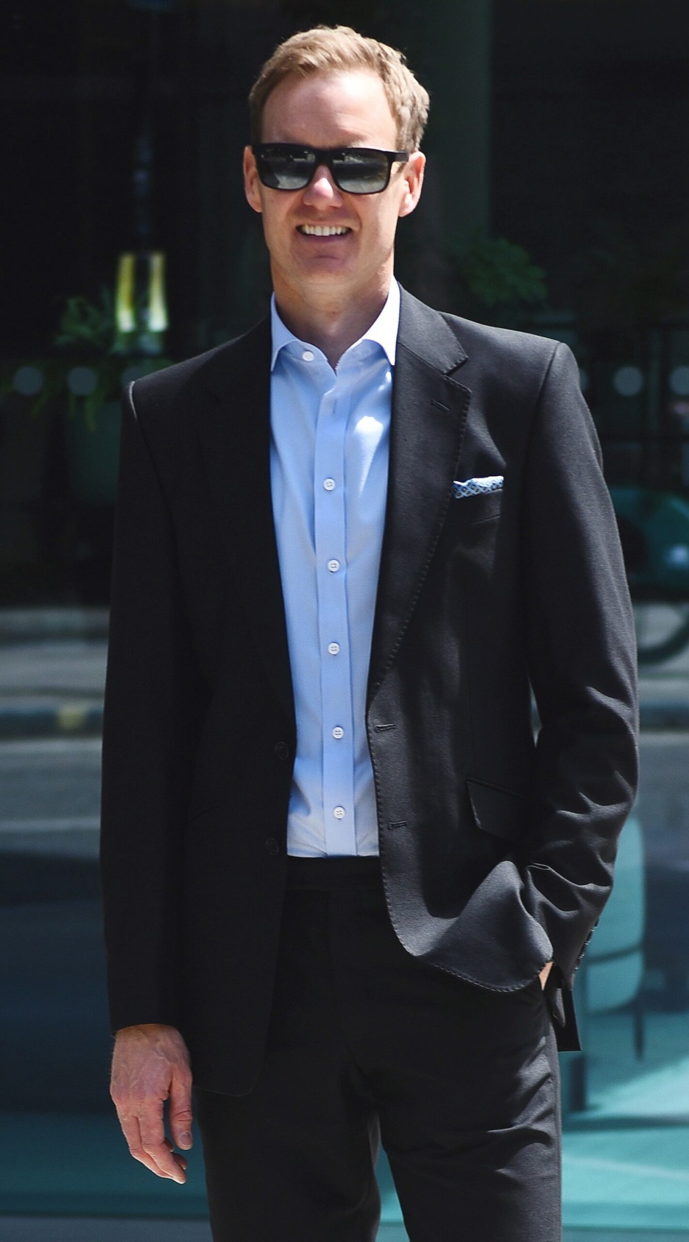 Dan Walker smiles with sunglasses on in the sun