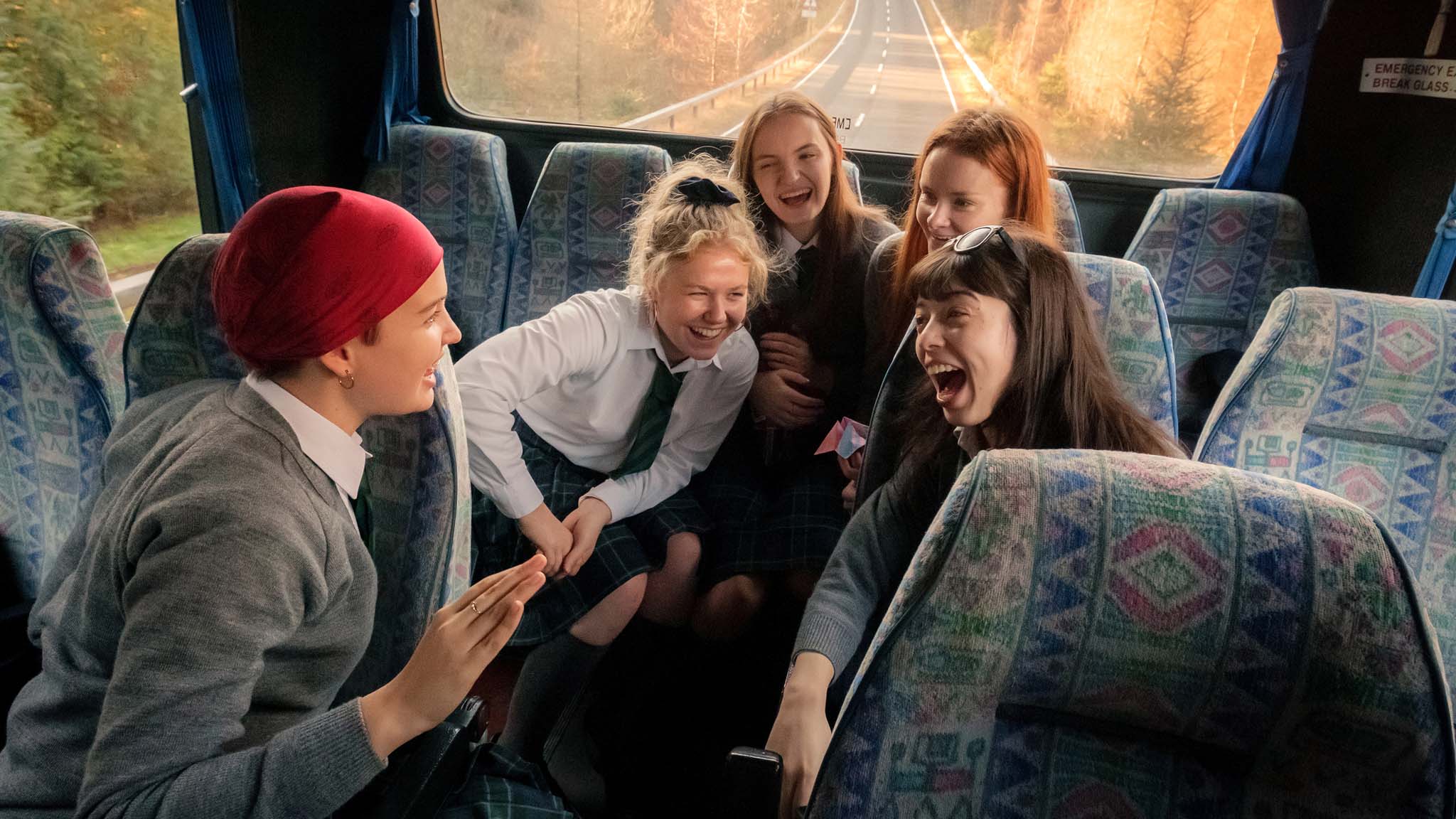 The schoolgirls from Our Ladies grinning at the back of a bus