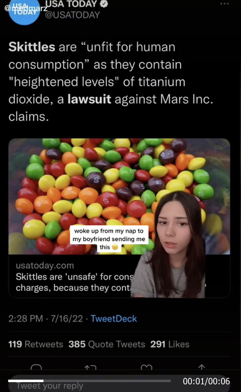 Woman sitting in front of a tweet about Skittles lawsuit on TikTok