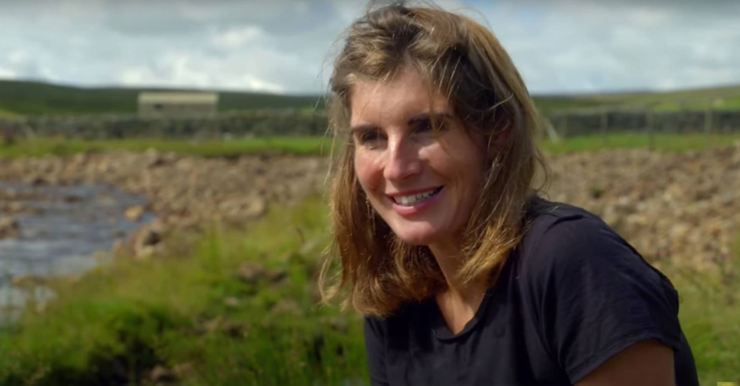 Amanda Owen smiles in front of fields