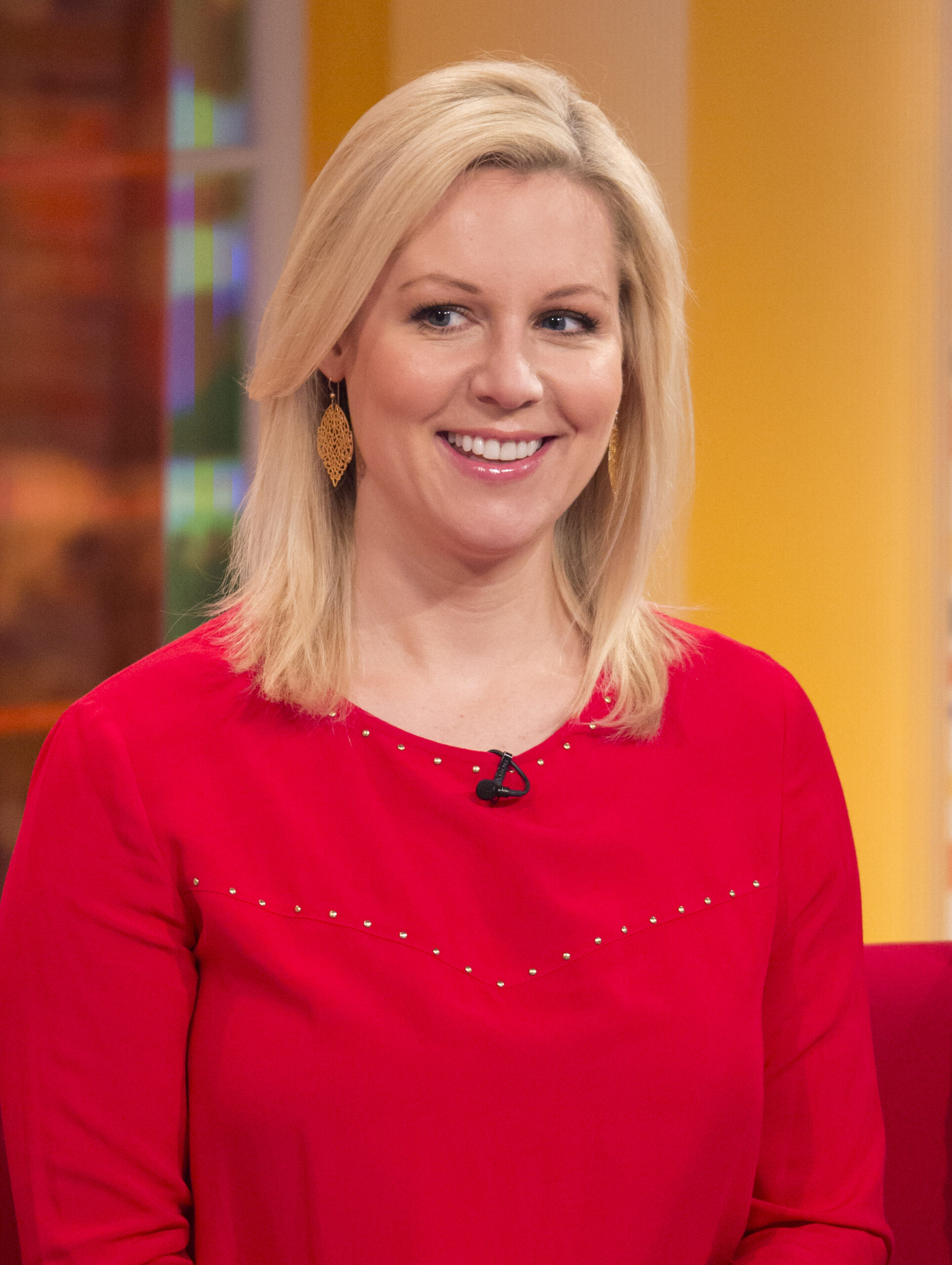 Abi Titmuss smiling wearing red