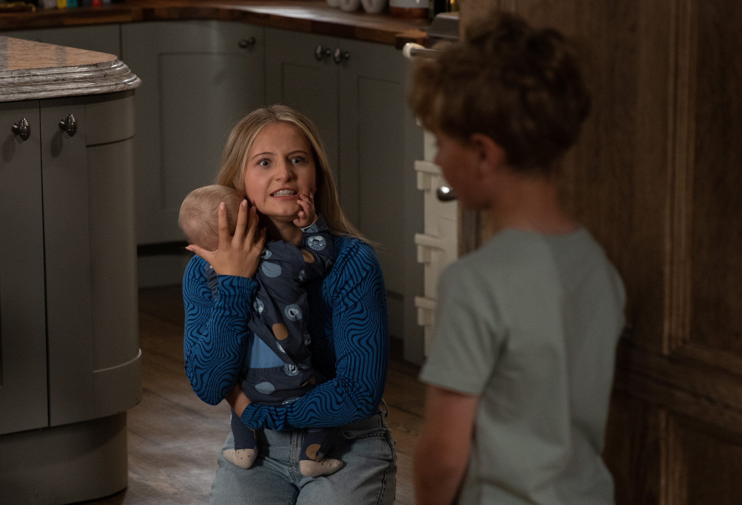 Amelia in Emmerdale on the floor holding baby Thomas (Credit: ITV)