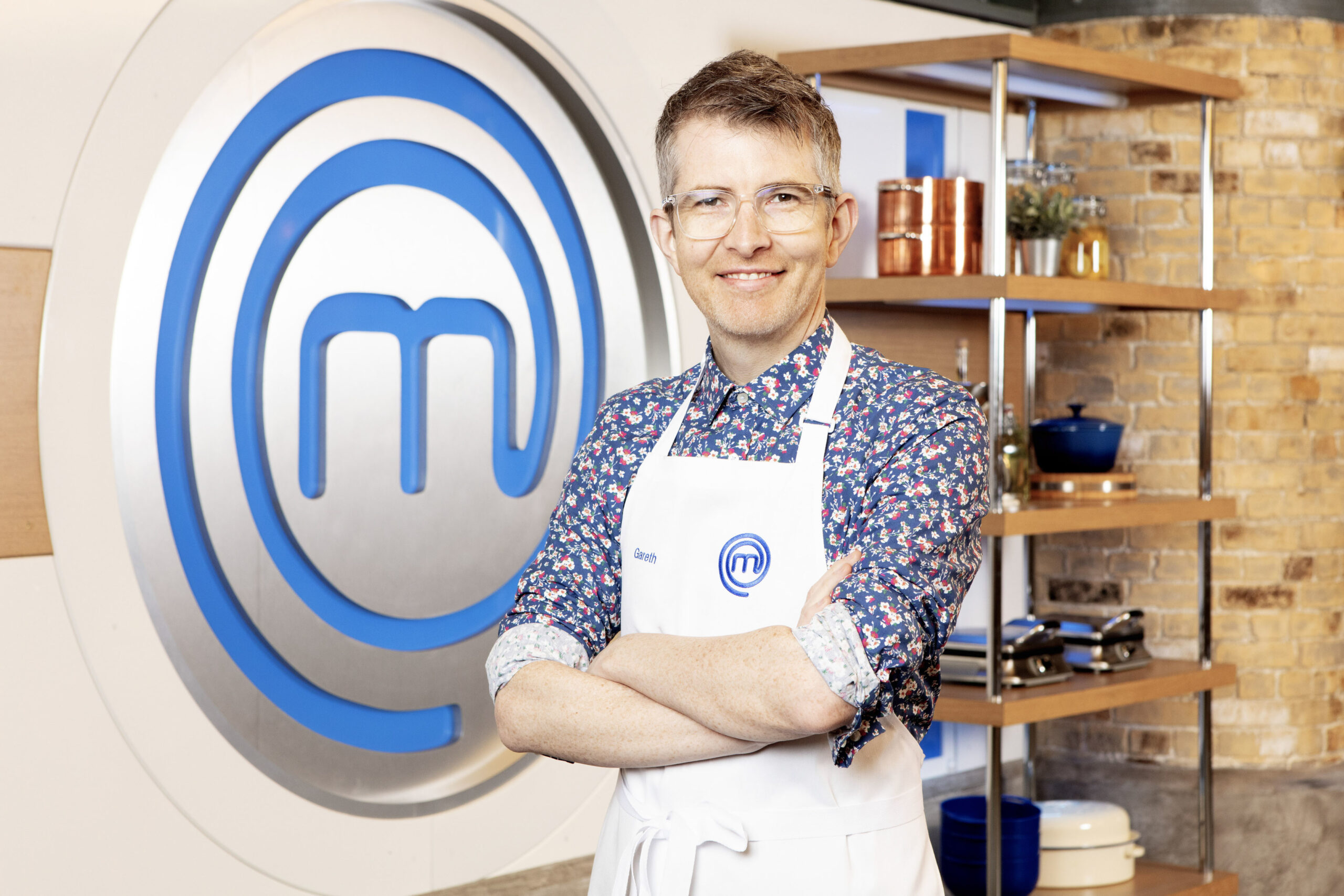Gareth Malone poses with masterchef logo and apron
