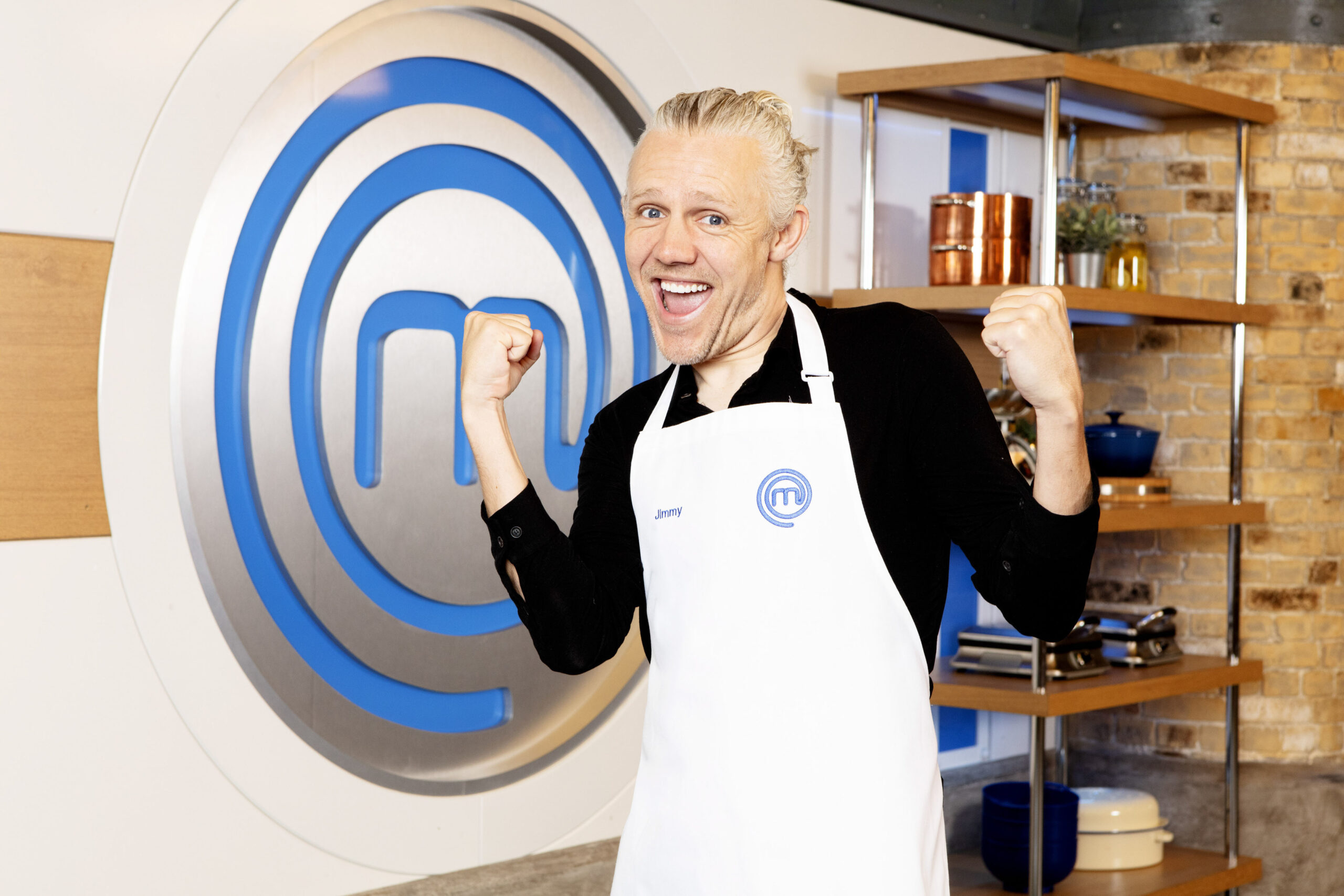 Jimmy Bullard smiles and poses with Masterchef logo