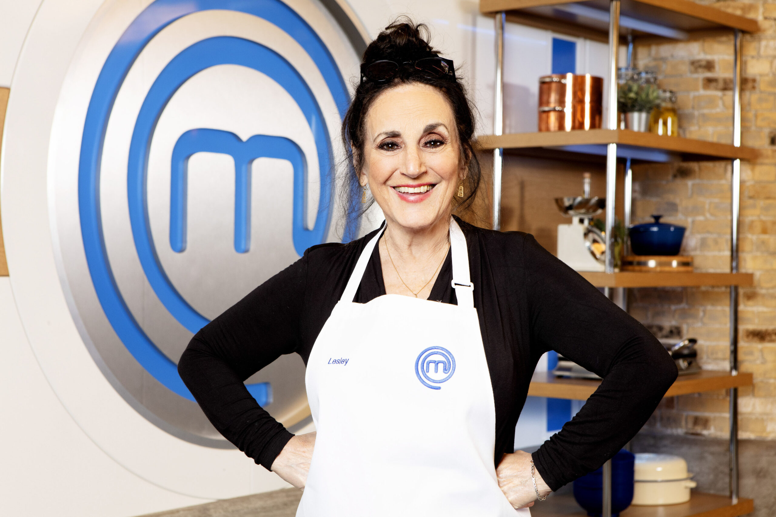 Lesley Joseph poses with hands on hips in masterchef apron