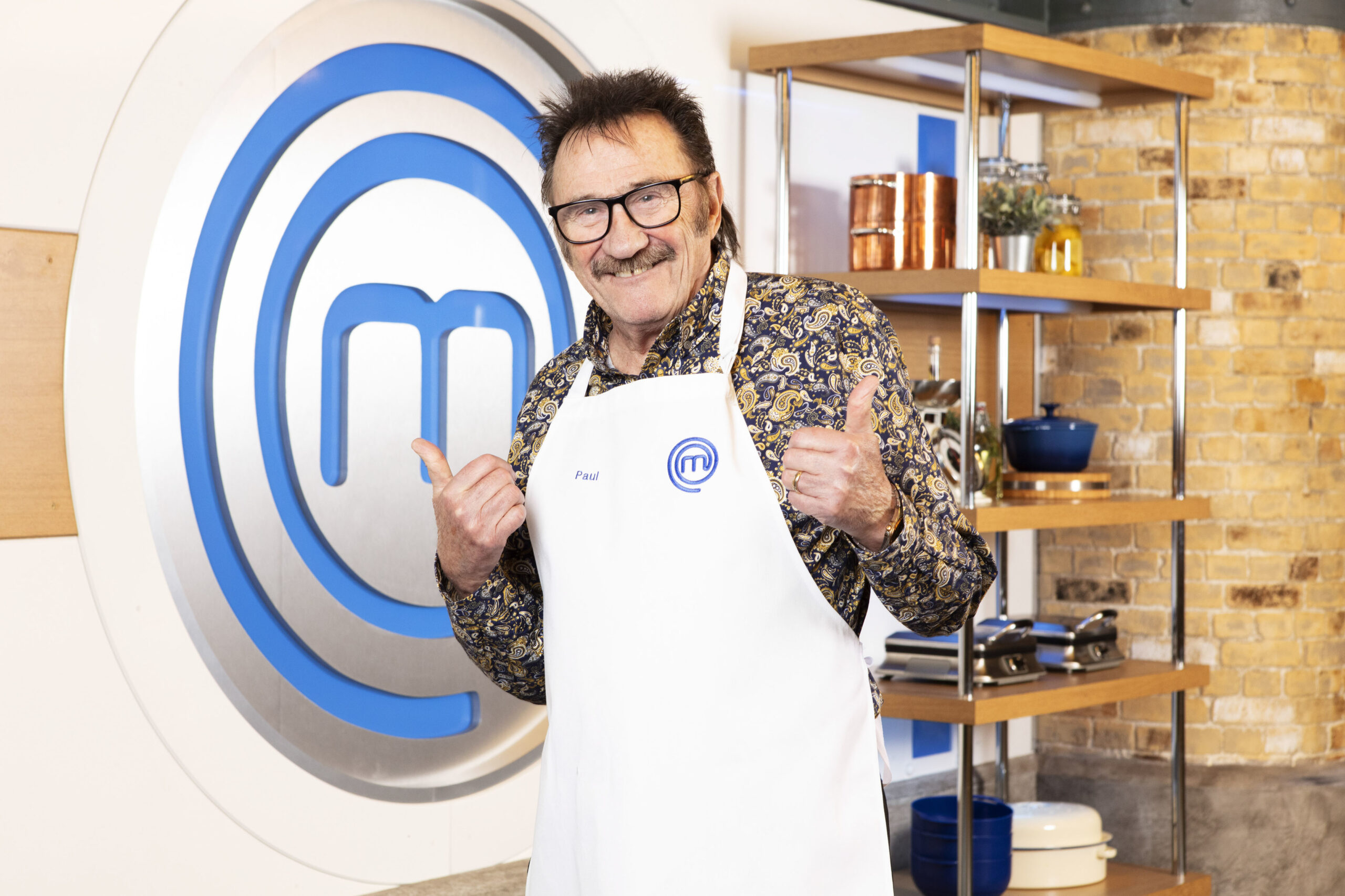 Paul Chuckle poses with his thumbs up in Masterchef apron
