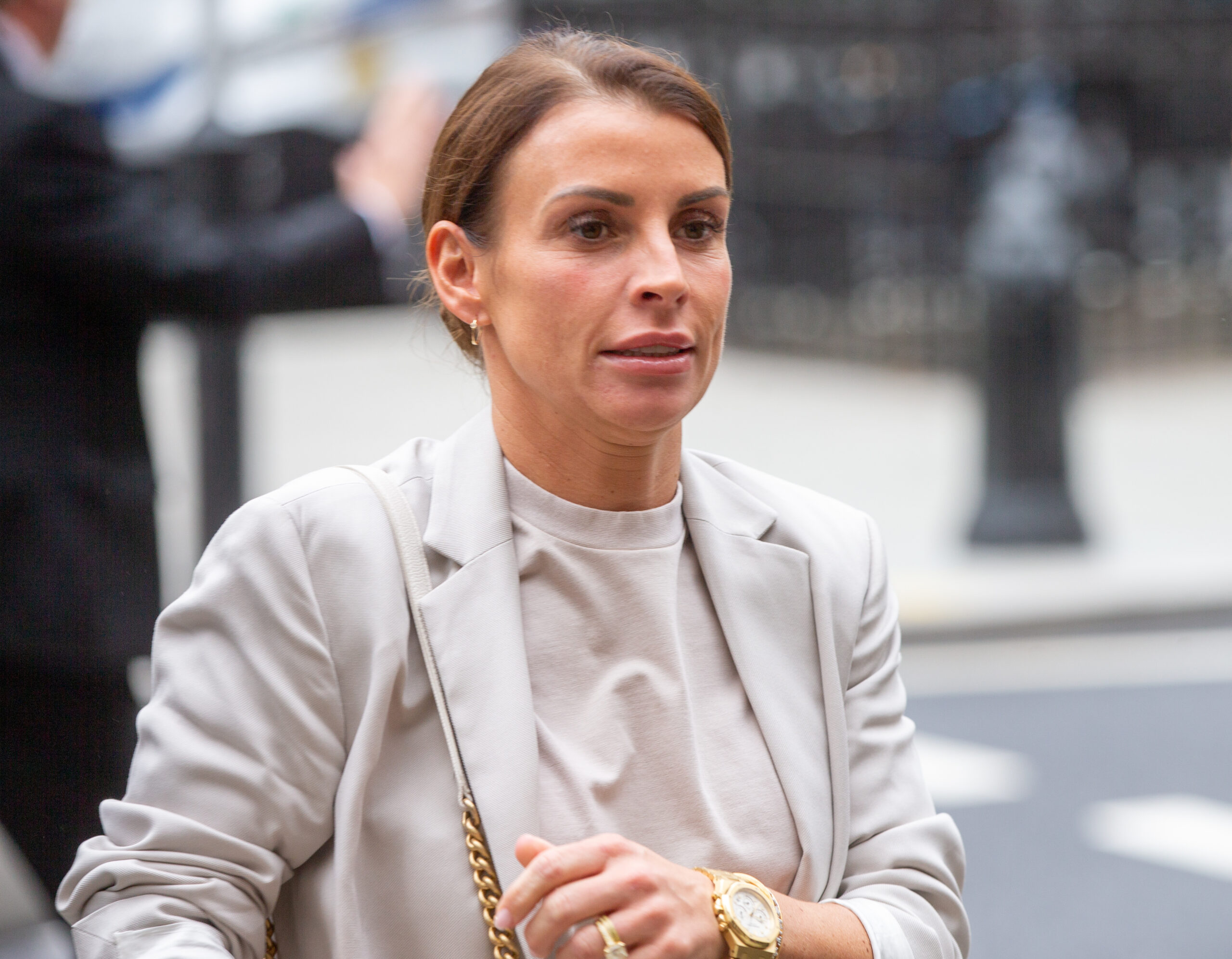 Coleen Rooney looks stressed as she tries to smile arriving at court