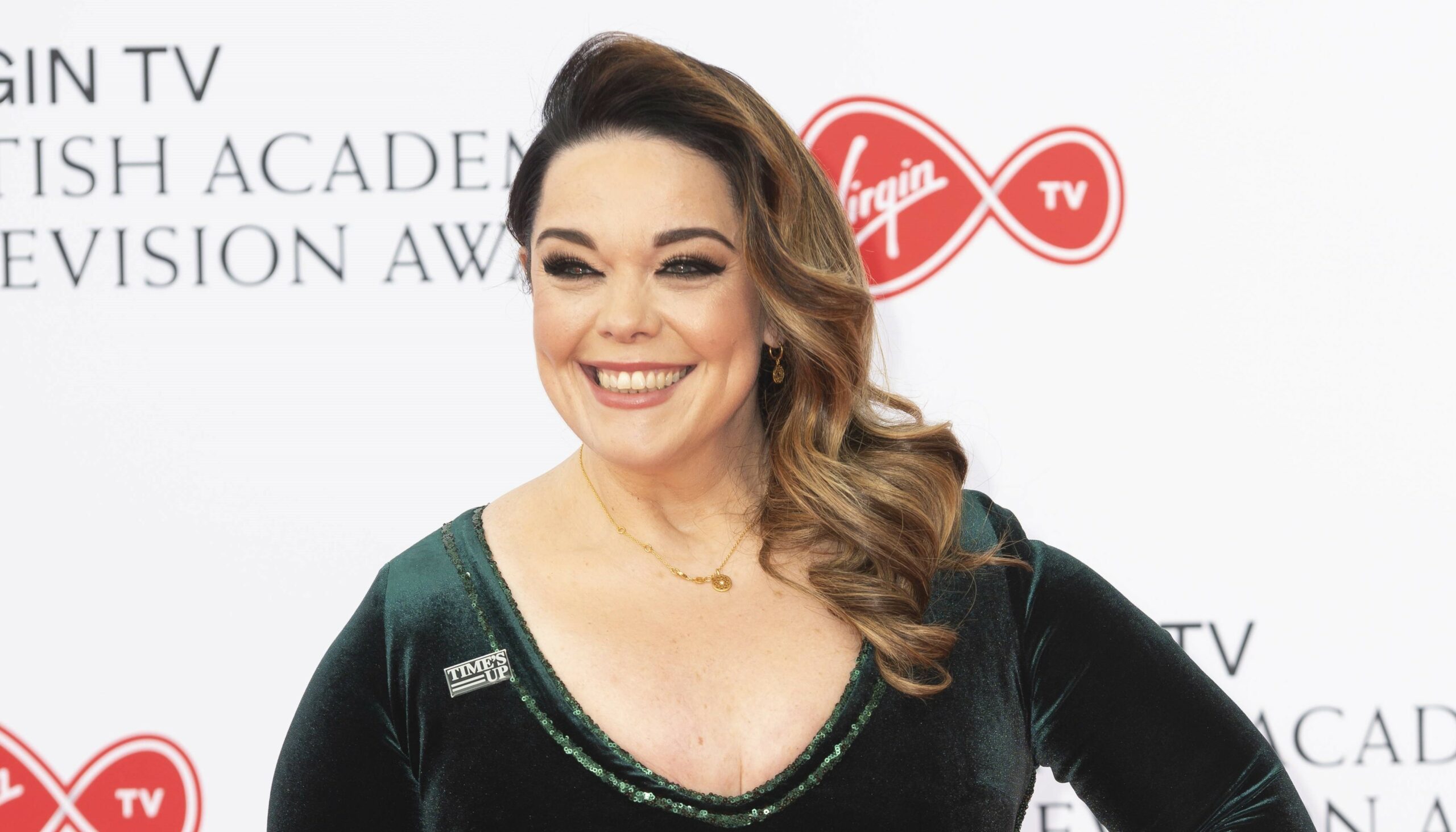 glam-looking Lisa Riley smiles on the red carpet at the BAFTAS