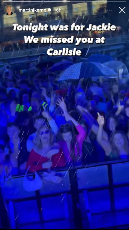 Fans of Martin stand at a barrier dancing. White writing is placed over the picture which reads 'Tonight was for Jackie. We missed you at Carlisle.'