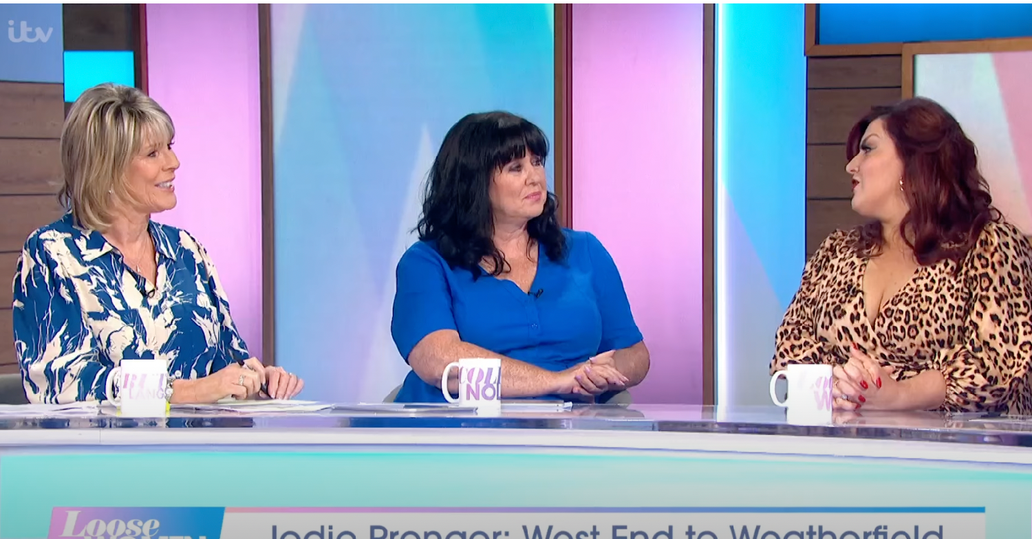 Ruth Langsford with Coleen Nolan and Jodie Prenger Loose Women panel behind desk talking with mugs