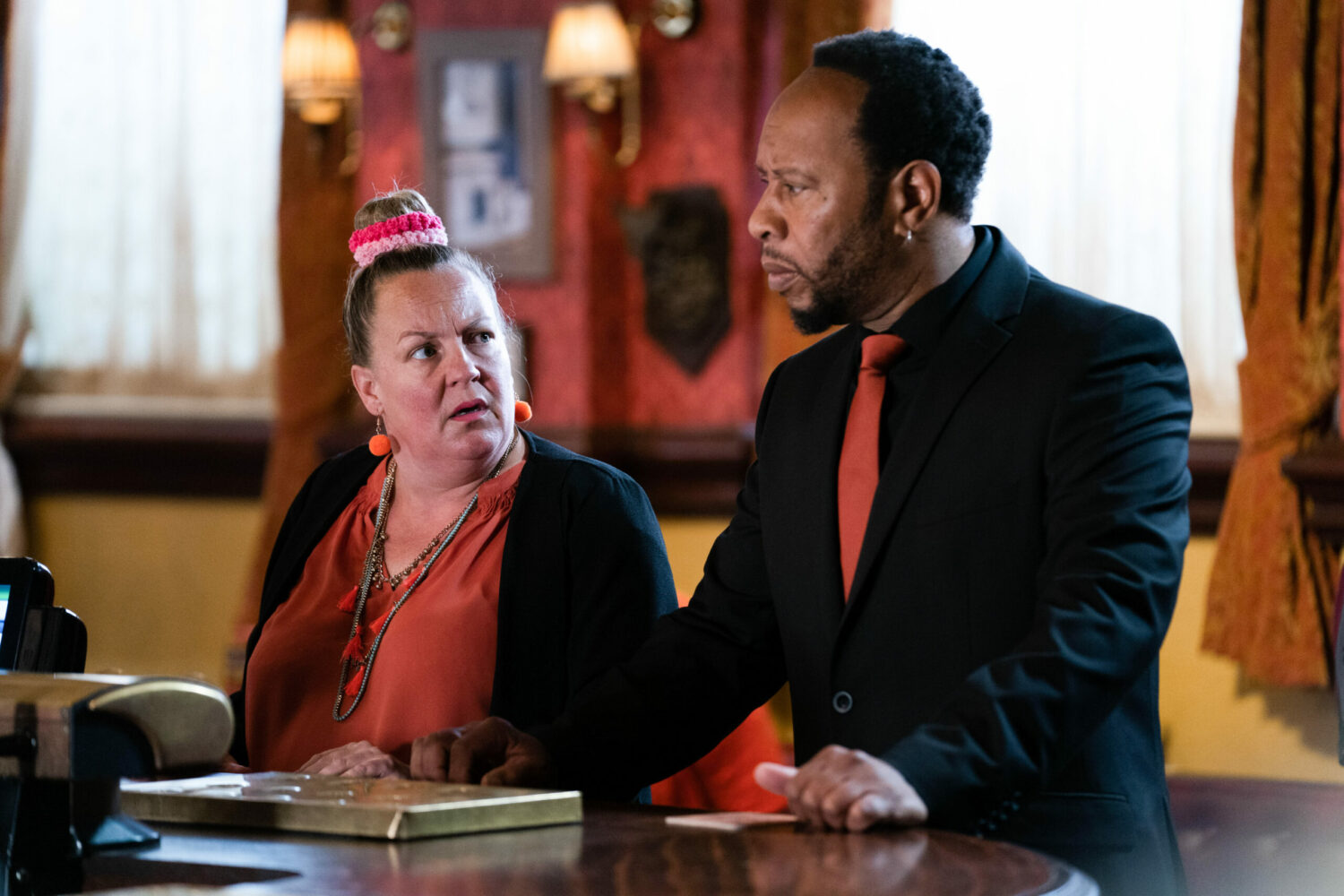 Karen and Mitch talking angrily at the bar in the Queen Vic on EastEnders