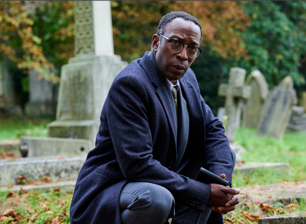 DI Ruiz crouches in a graveyard in The Suspect on ITV