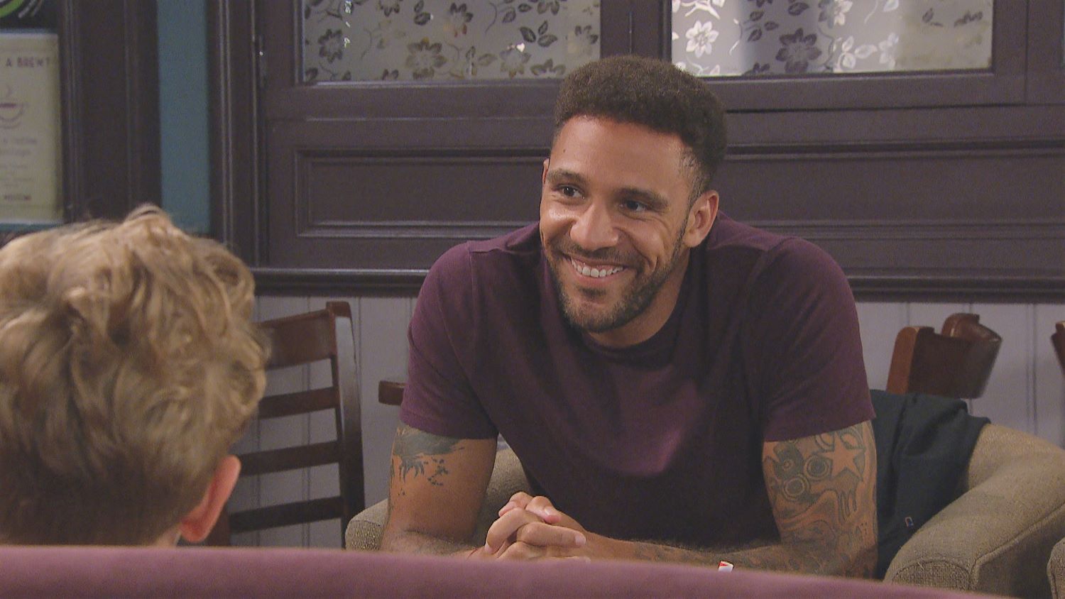 Billy Fletcher smiling at Dawn and Lucas in the cafe in Emmerdale 