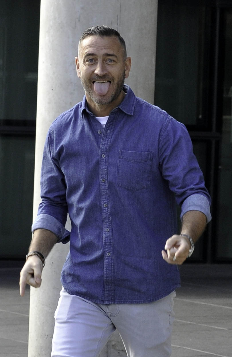 Actor Will Mellor sticks tongue out and points to camera. 