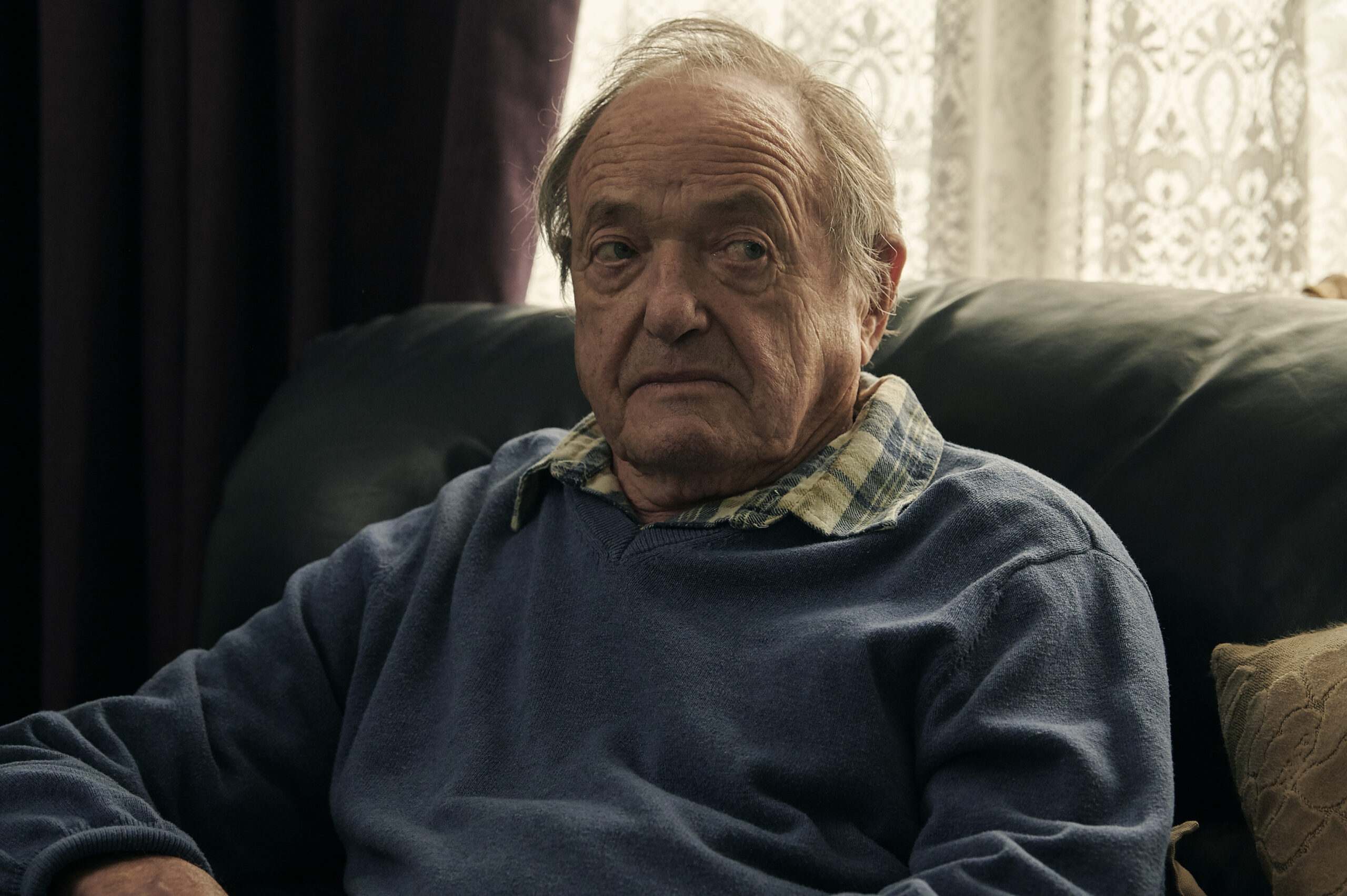 James Bolam as Gerry, he looks displeased sitting on a chair in BBC Marriage cast