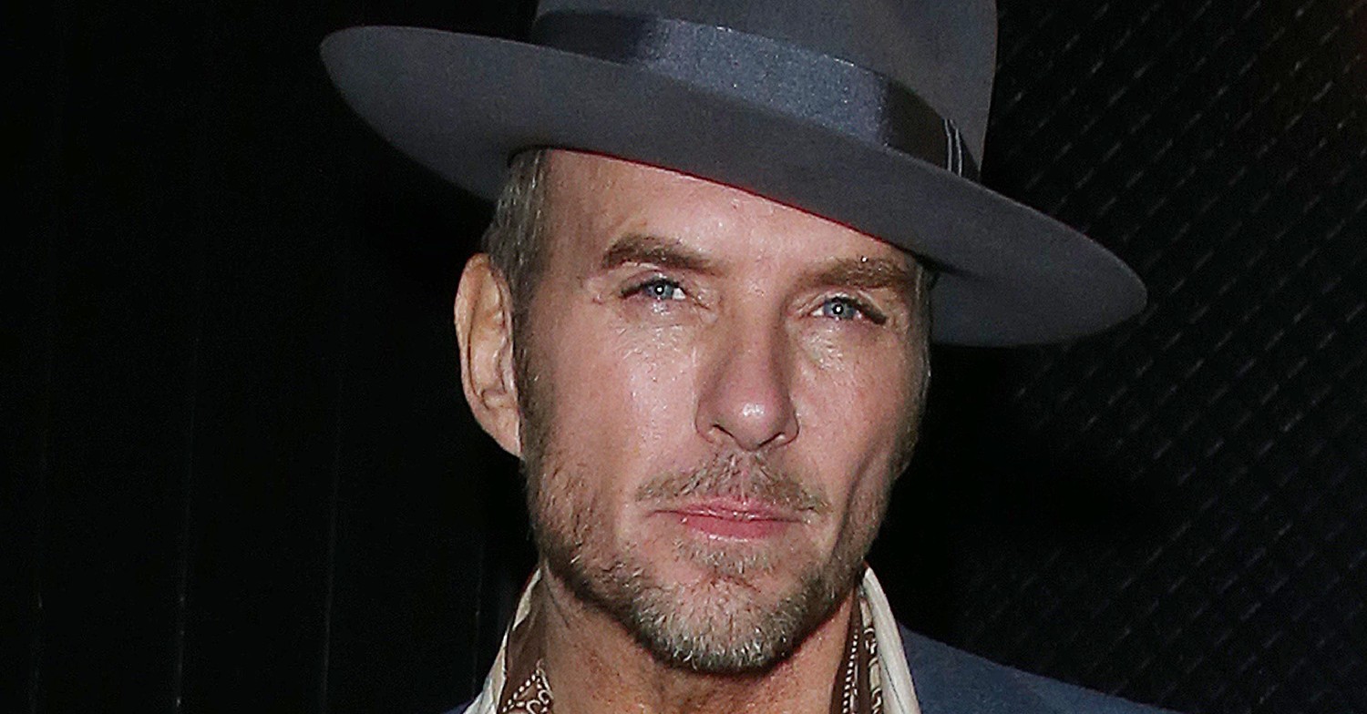 Matt Goss smiles with hat on at event