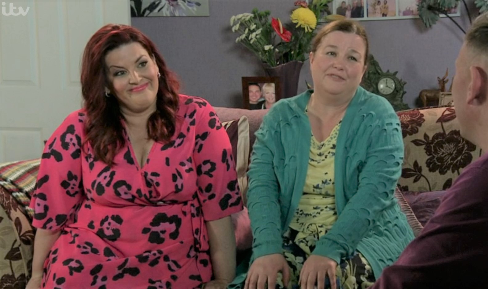 Glenda Shuttleworth and Mary Taylor sit on the sofa and smile in Coronation Street