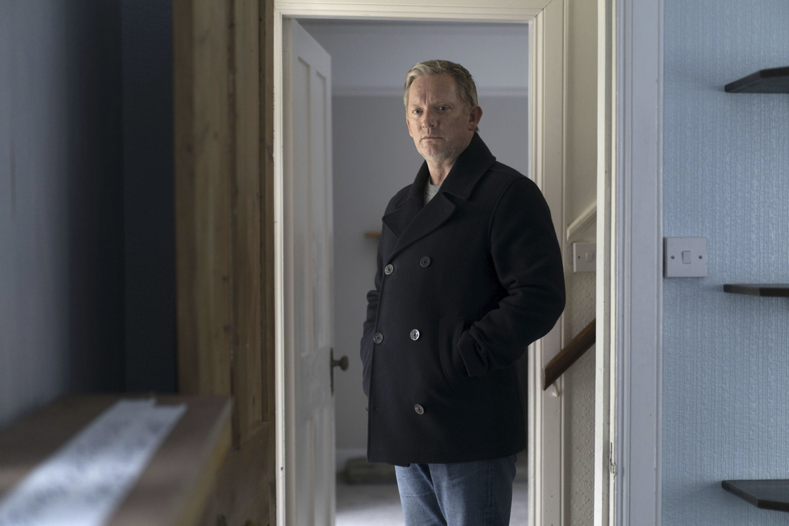Douglas Henshall as Jimmy Perez in Shetland series 7, he stands in a doorway