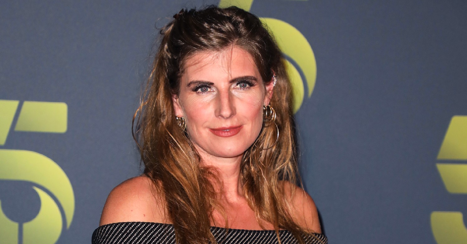 Amanda Owen in front of Channel 5 promo board in an off the shoulder grey dress