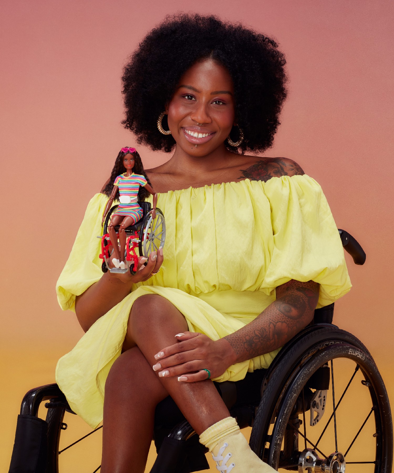 Model poses with Barbie doll in wheelchair