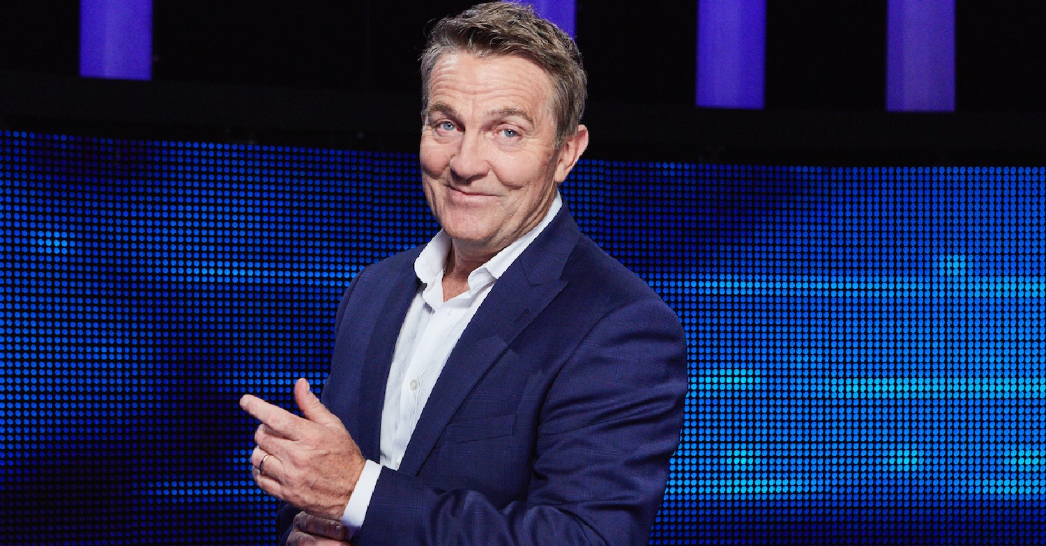 Bradley Walsh smiling in navy suit and white shirt on The Chase