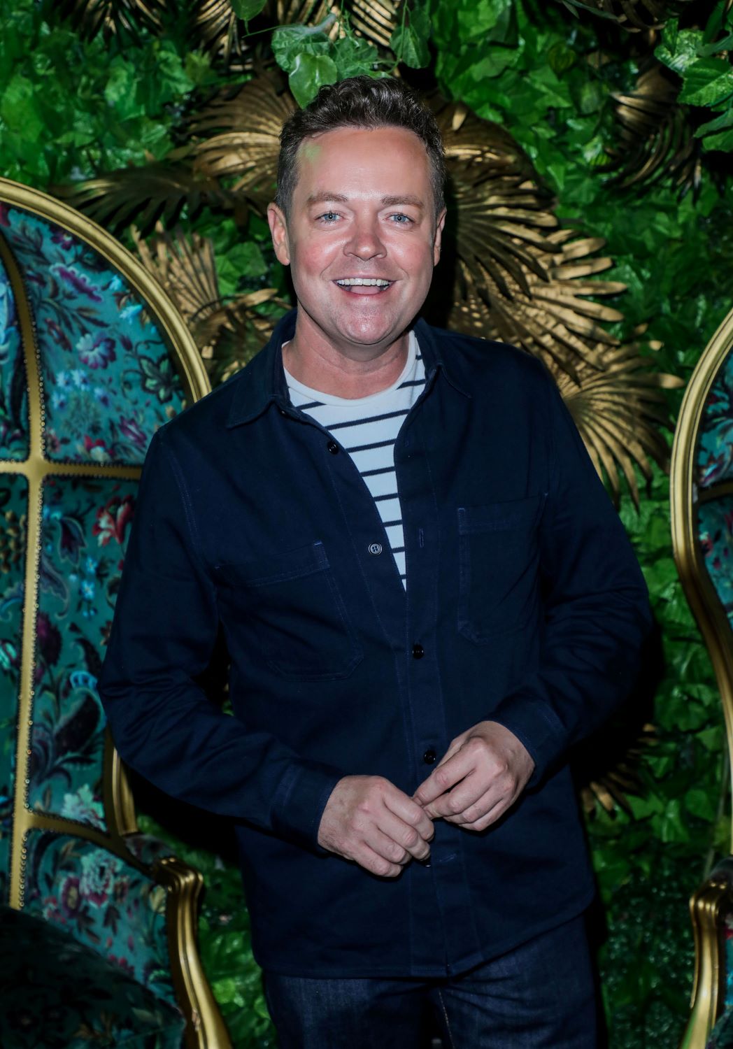 Stephen Mulhern smiles in front of a jungle background