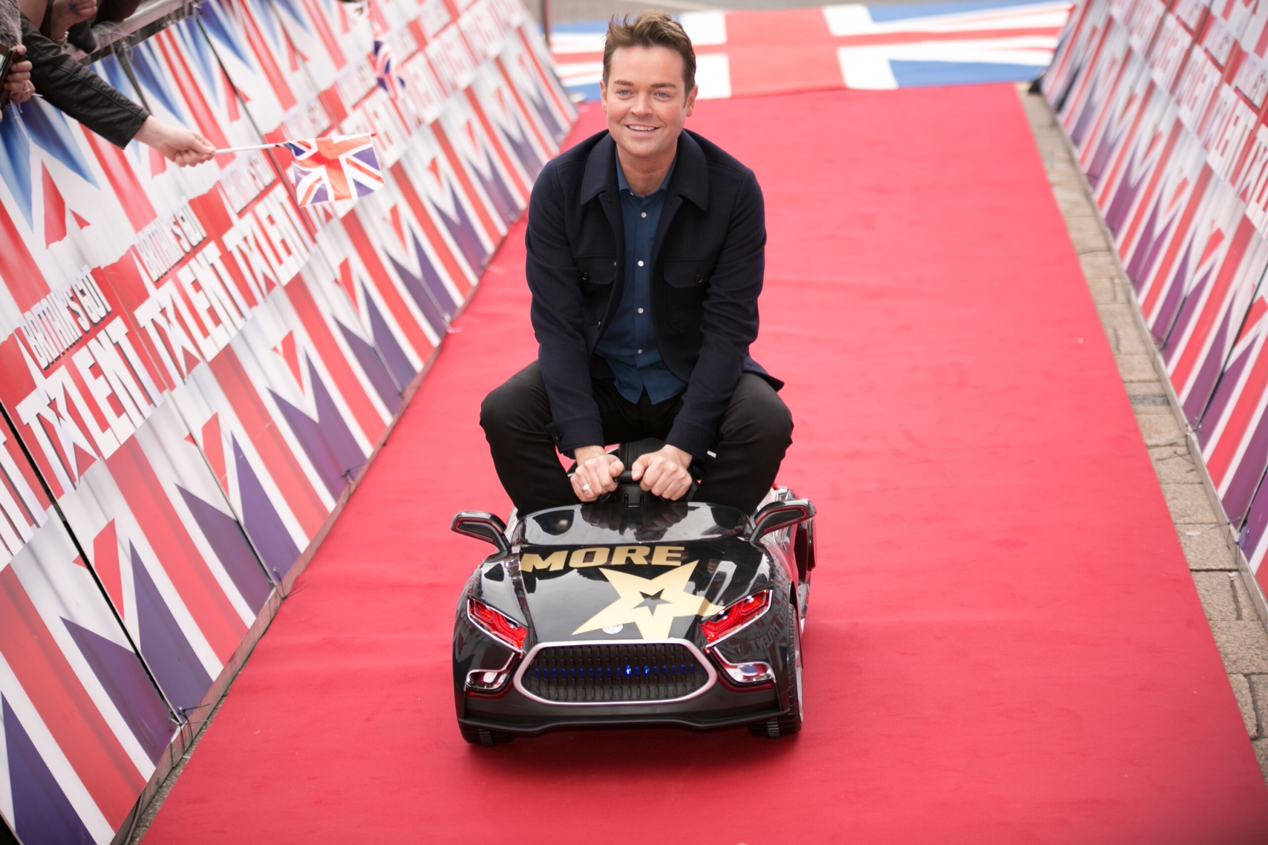 BGT presenter Stephen Mulhern on the red carpet in a toy car