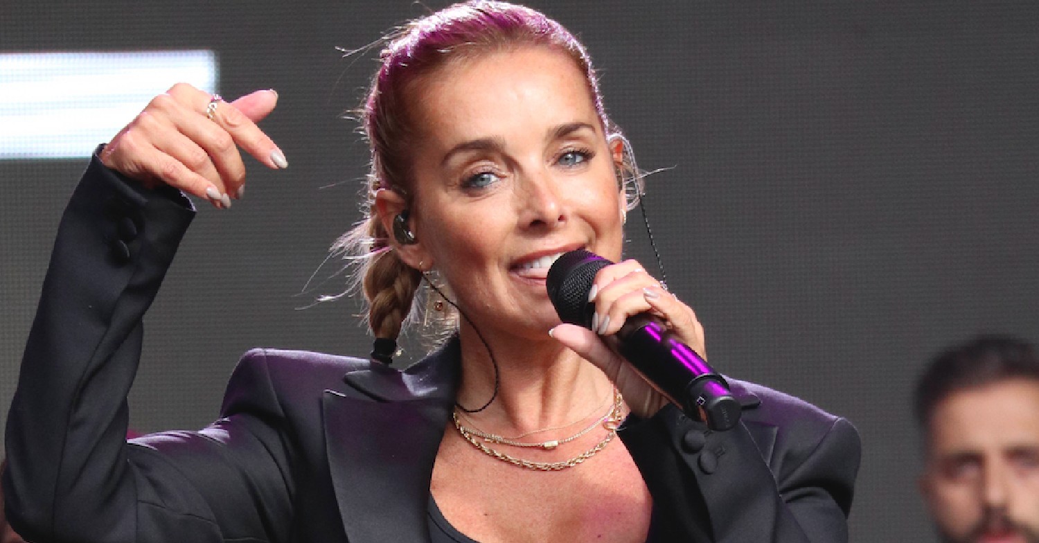 Louise Redknapp performing with microphone and her hair up