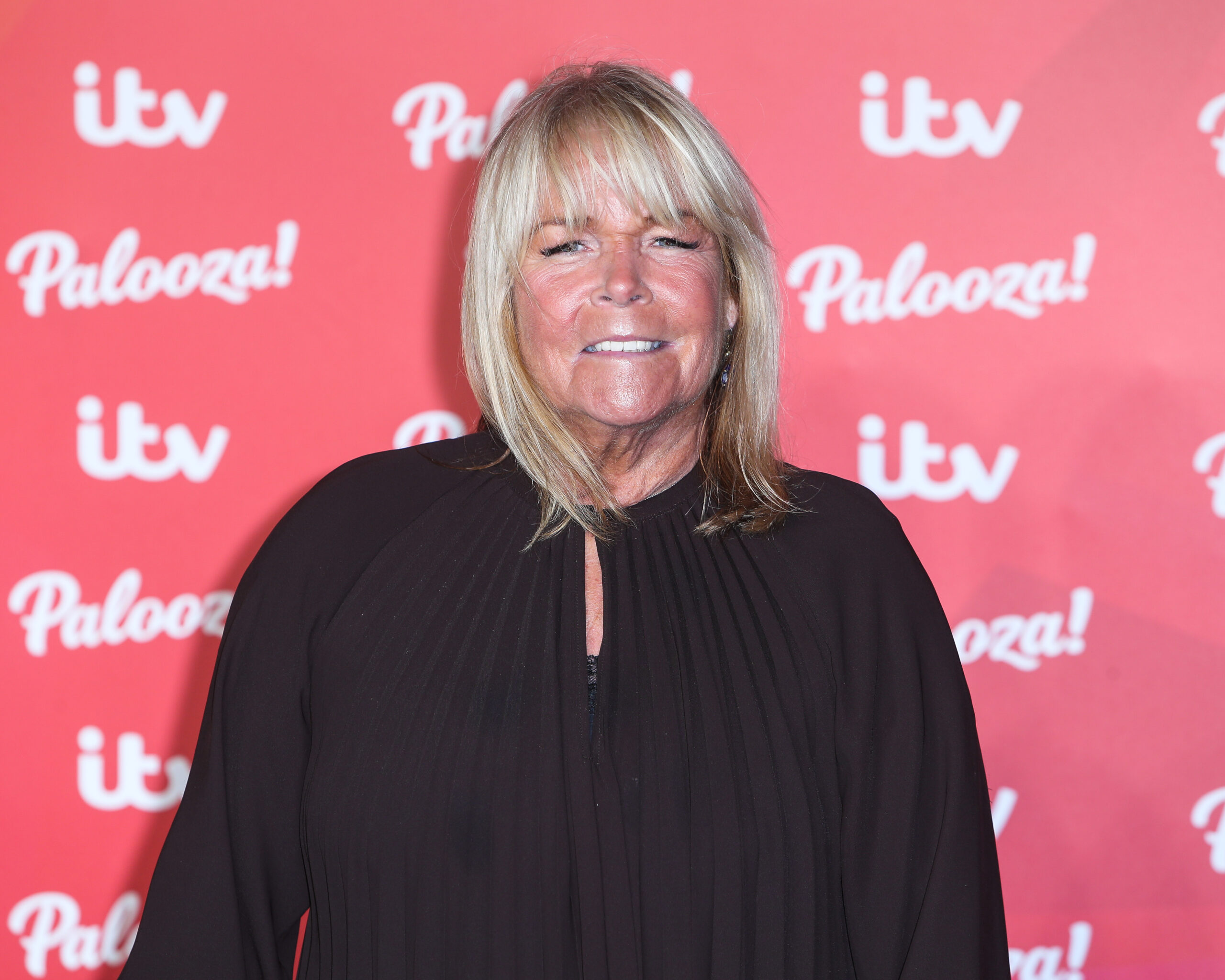 Linda Robson smiles while dressed in black