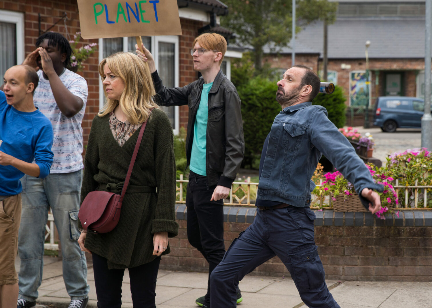 Coronation Street's Griff looking angry at a protest with Toyah standing on looking sad