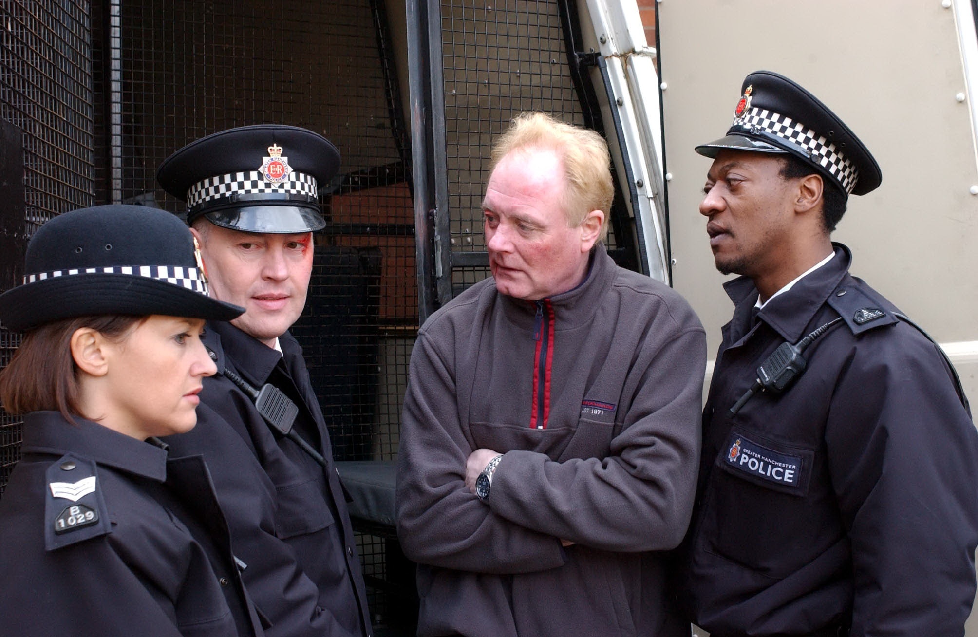 Coronation Street TV - 2003 - Realising that he has gone too far Mick Hopwood [Ian Gain] panics and has Les Battersby [Bruce Jones] arrested by PC Rossington [Everal Walsh] for assaulting a police officer. Emma Watts [Angela Lonsdale] knows he went too far but as Les claims police brutality and Mick puts her under pressure she's torn