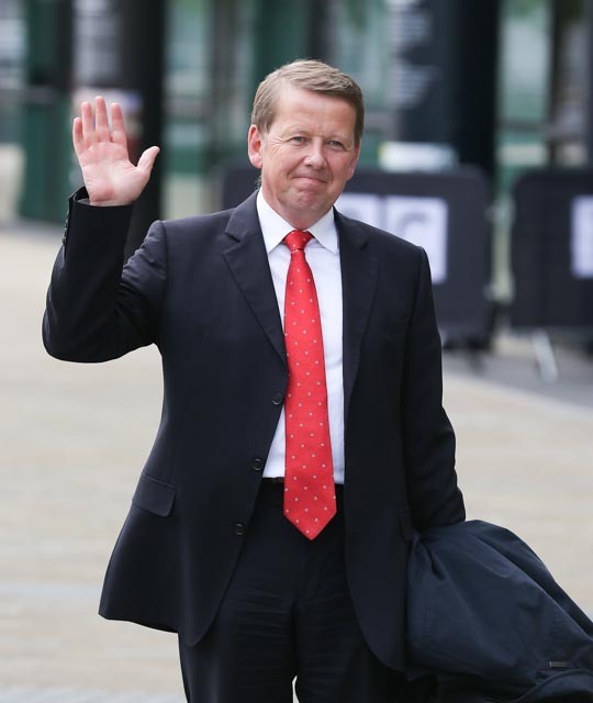BBC star Bill Turnbull waves to camera while wearing red tie