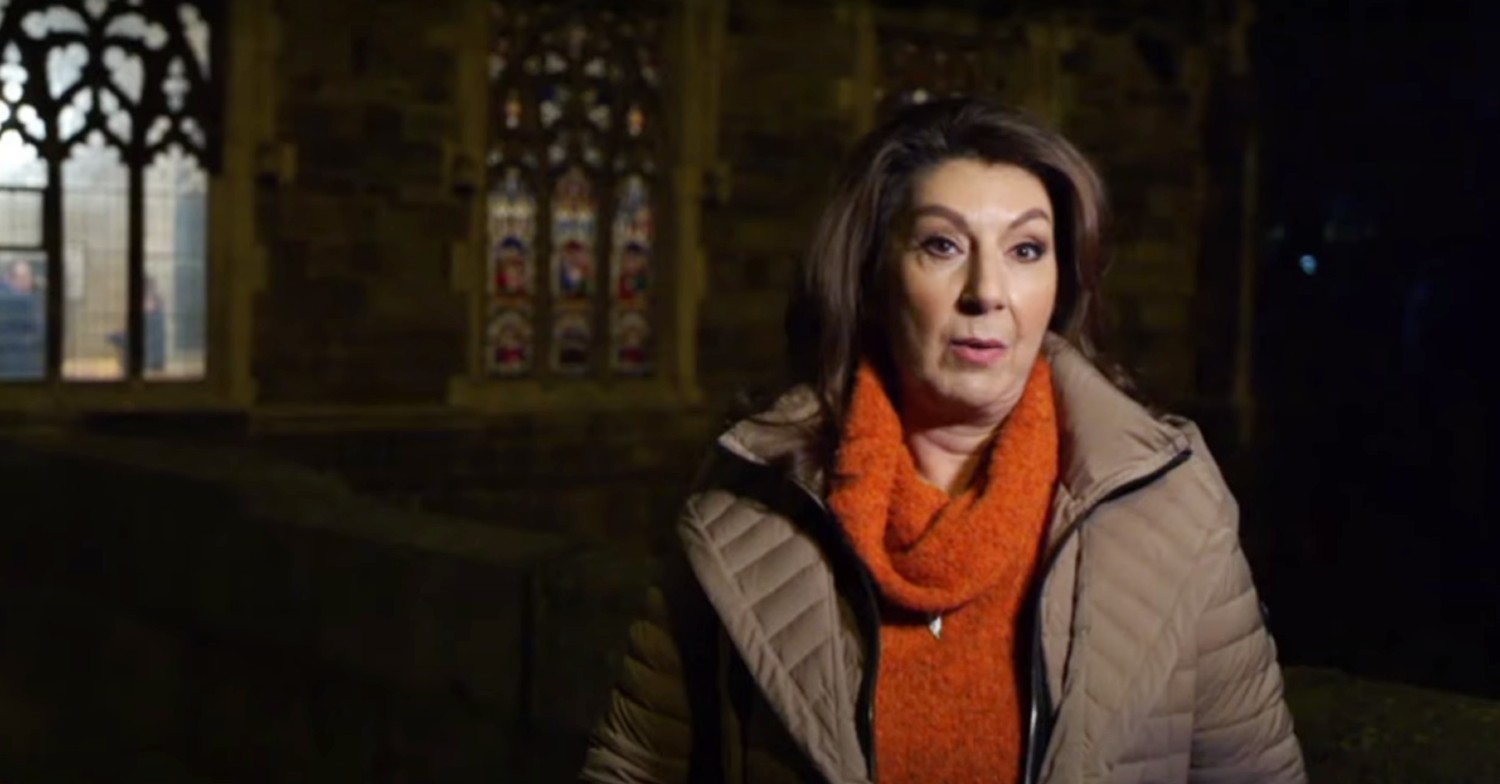 Jane McDonald speaking outside a church at night