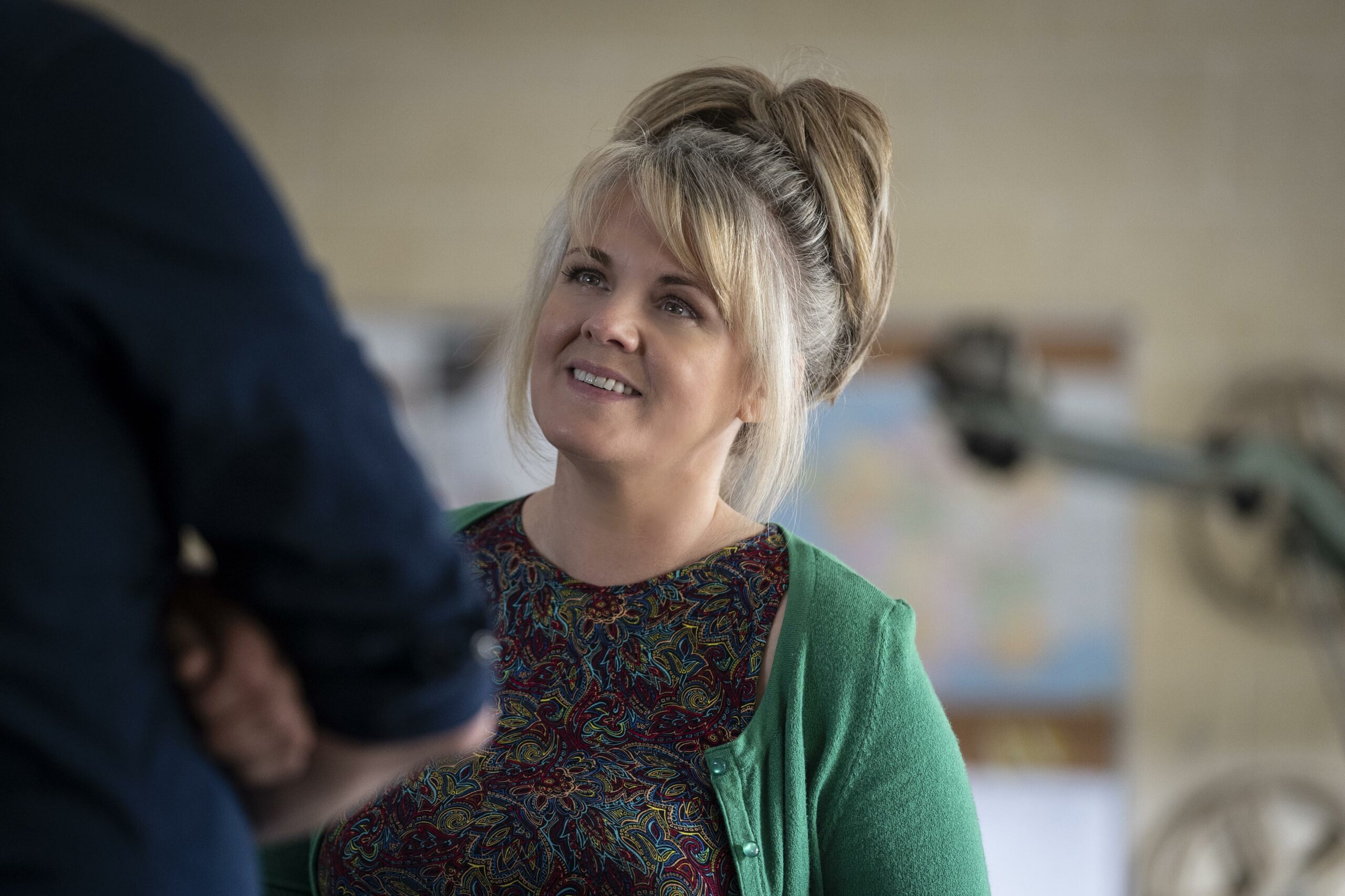 SALLY LINDSAY AS JEAN WHITE, SHE SMILES LOOKING UP AT DOM