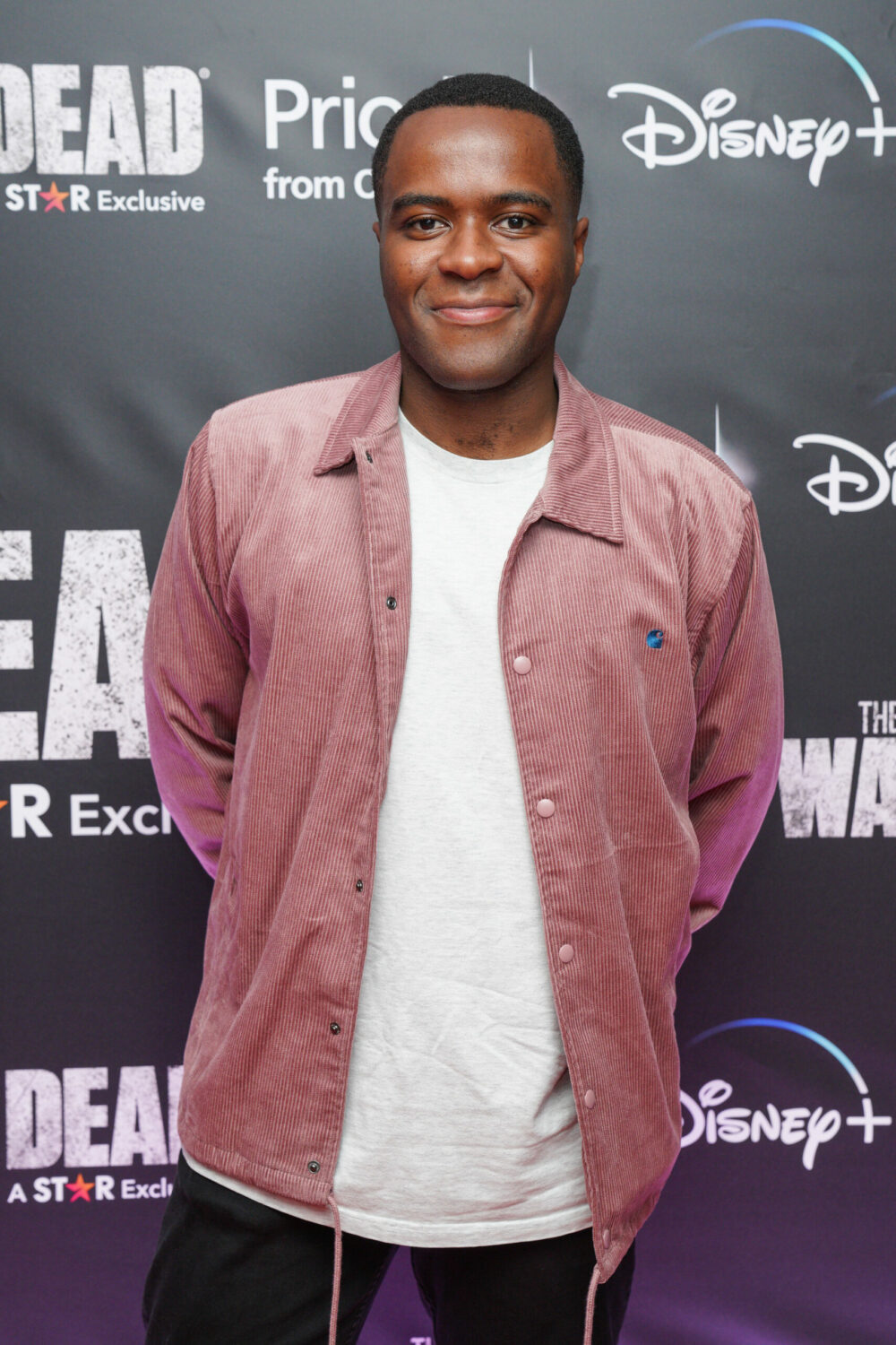 Liam Charles smiles in pink jacket