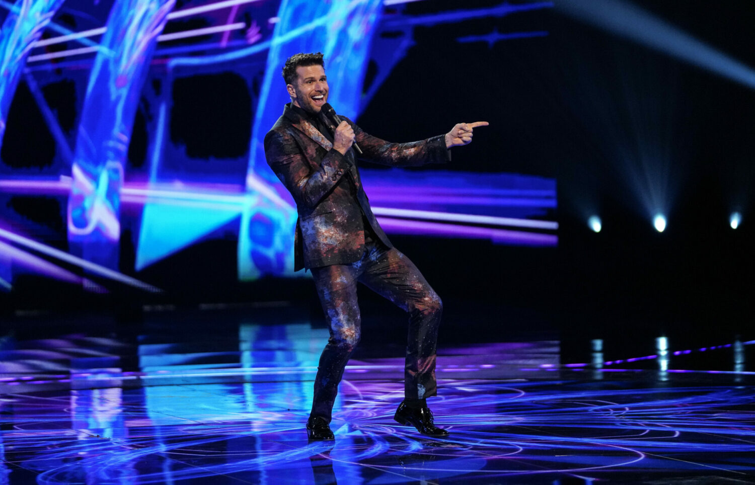 Joel Dommett smiles and points at contestant on The Masked Dancer