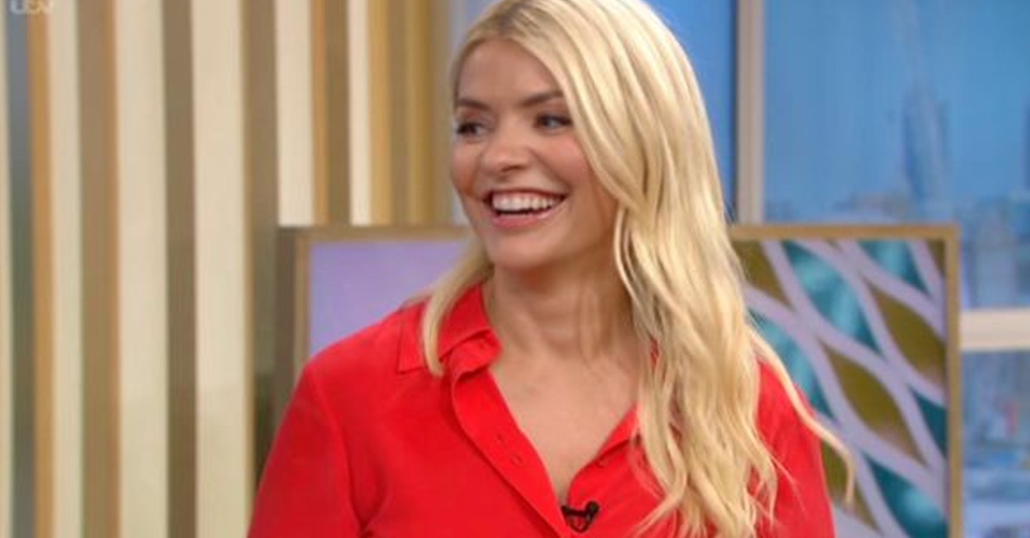 Holly Willoughby smiling wearing red and showing off her hair on ITV This Morning