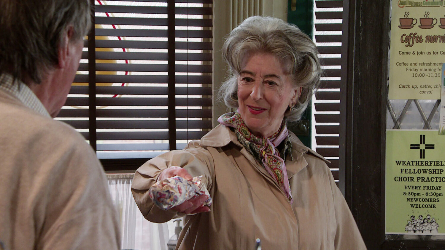 Coronation Street Roy and Evelyn as she smiles handing him a present