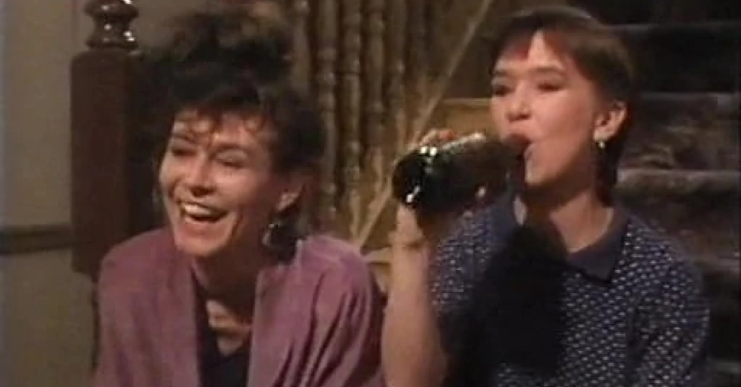 Rachel laughing and Michelle drinking from the bottle on EastEnders 